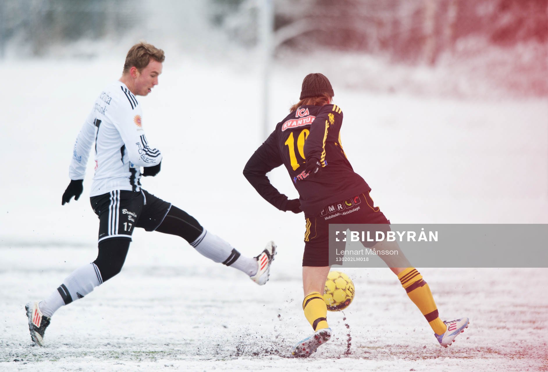 Fot, fotboll, fotbollsskor. Snö, snöig konstgräsplan.