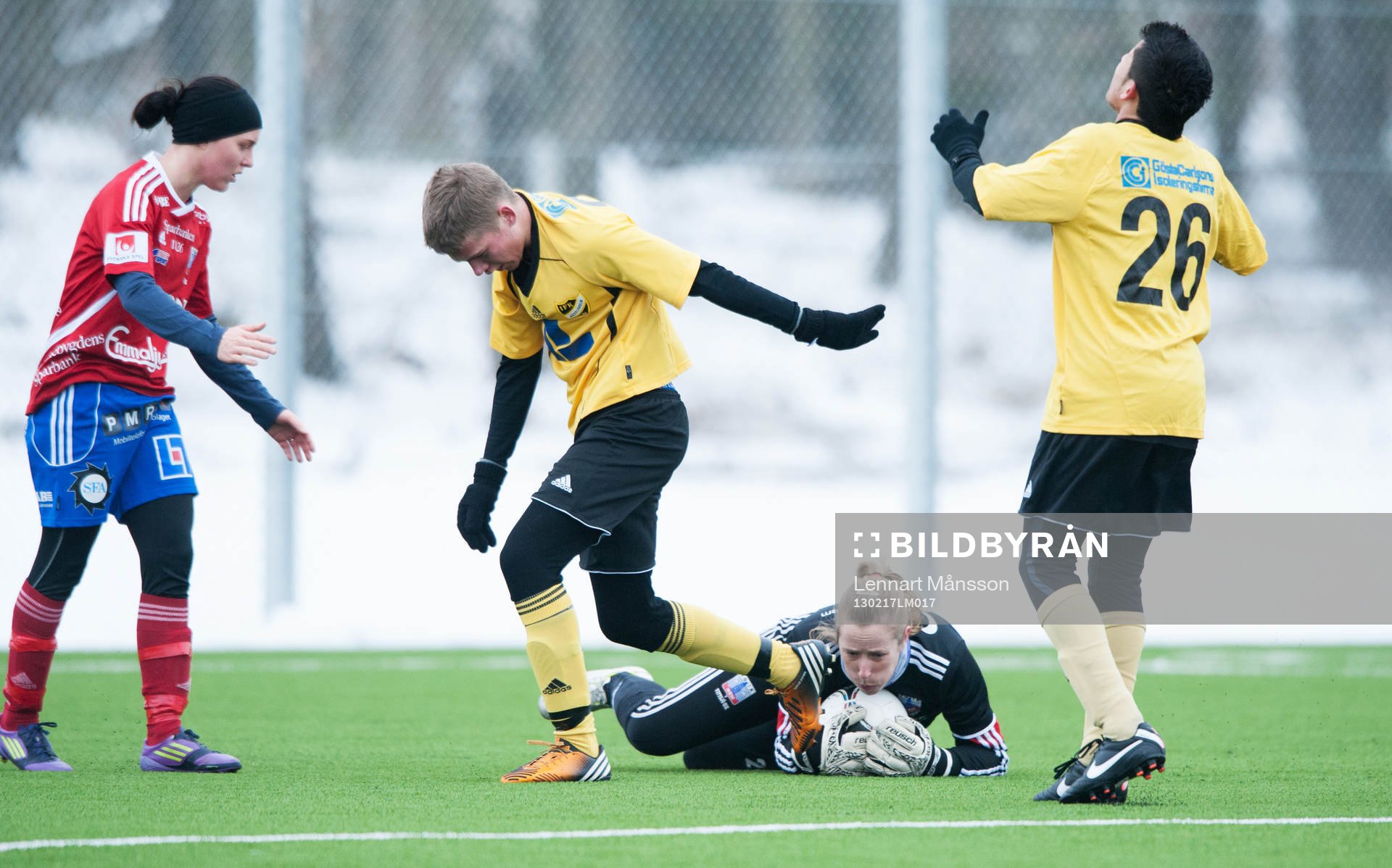Målvakt greppar bollen framför forwards