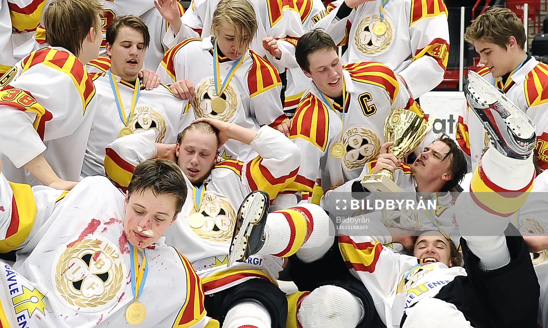 Brynäs spelare i en hög med pokalen
