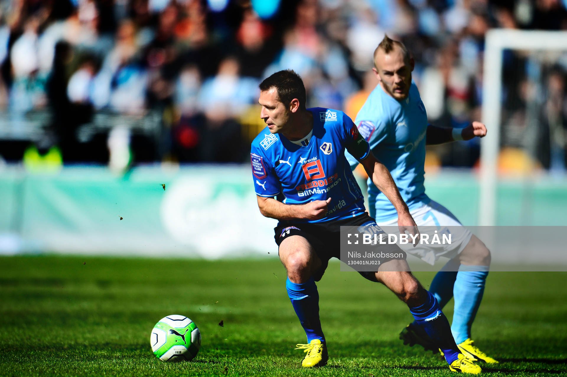 Fotboll, Allsvenskan, Malmö FF - Halmstad: Stefan Selakovic, Halmstad med bollen, Magnus Eriksson, Malmö FF i bakgrunden.
