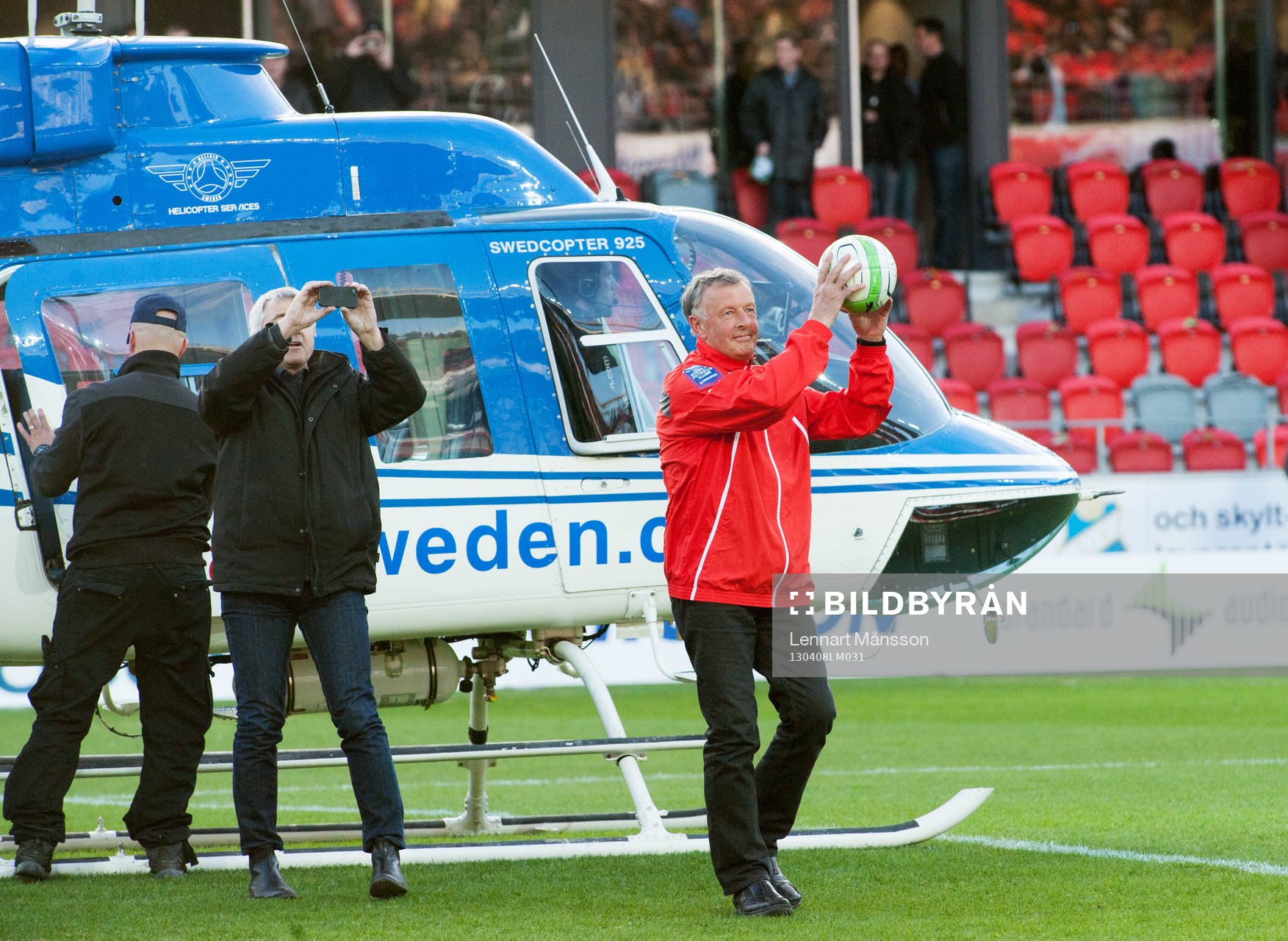 Helikopter landar på Myresjö arena i solnedgången,