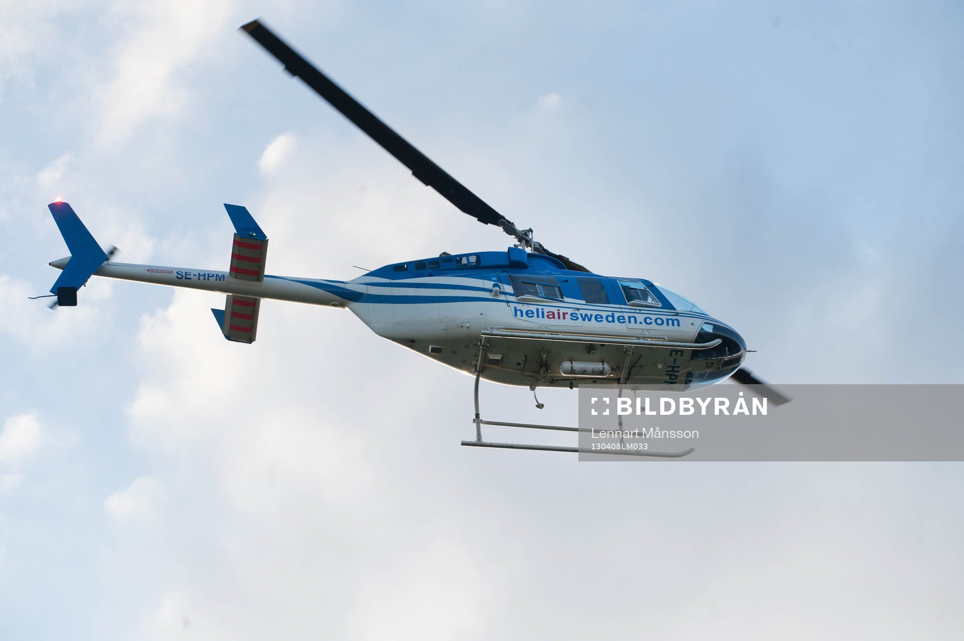 Helikopter lyfter mot blå himmel