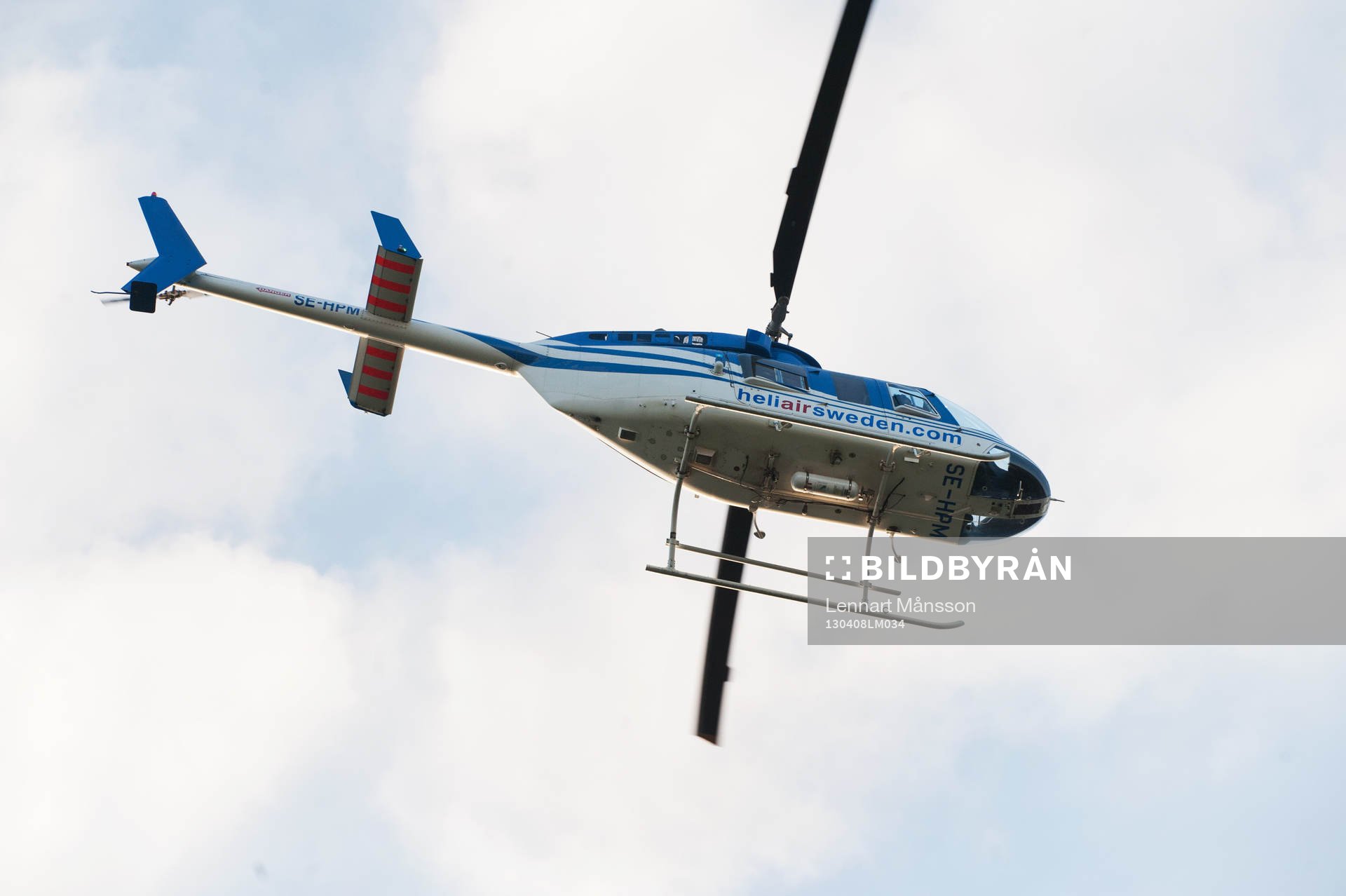 Helikopter lyfter mot blå himmel