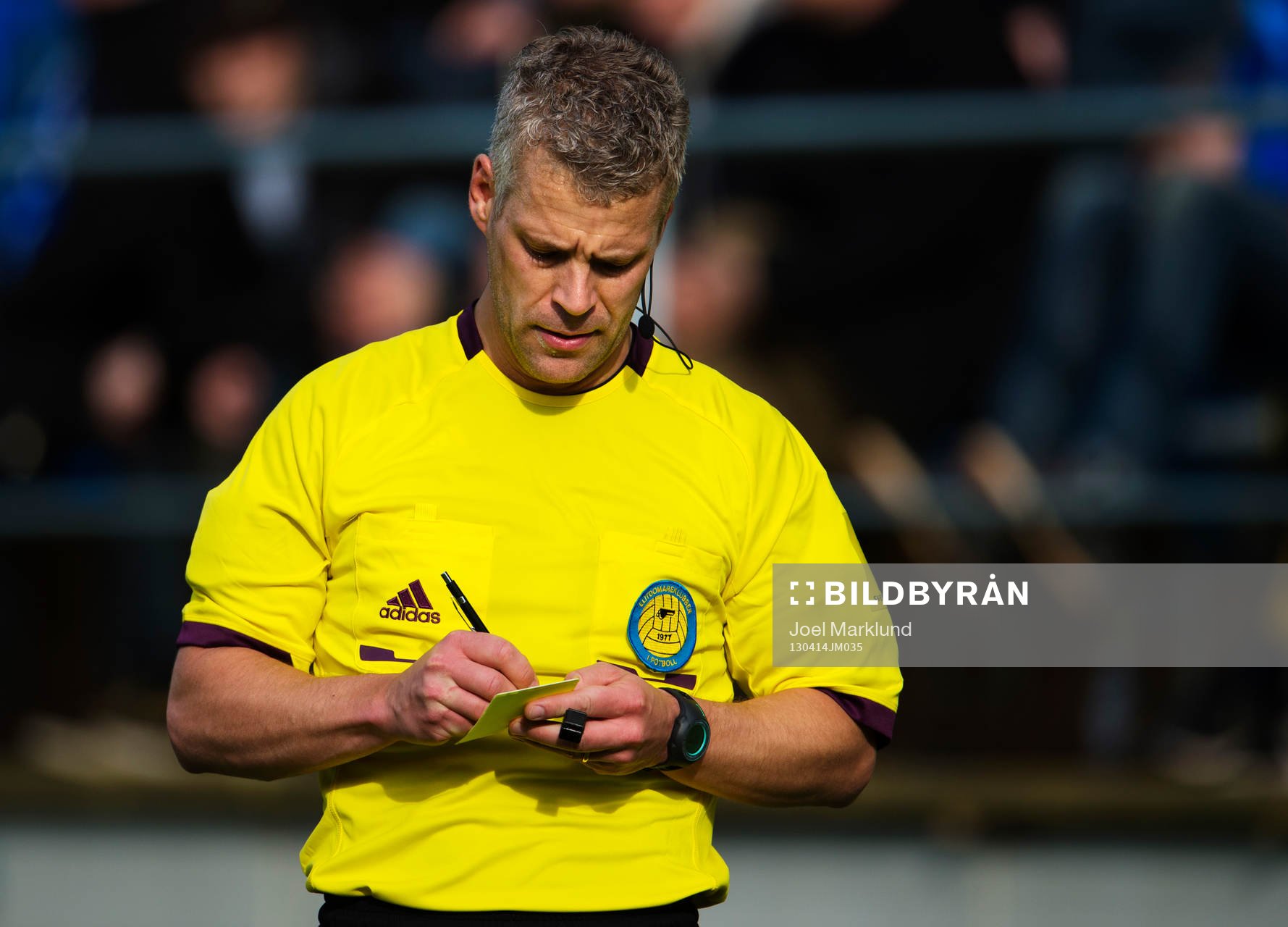 Tobias Mattsson, domare, antecknar på ett gult kort