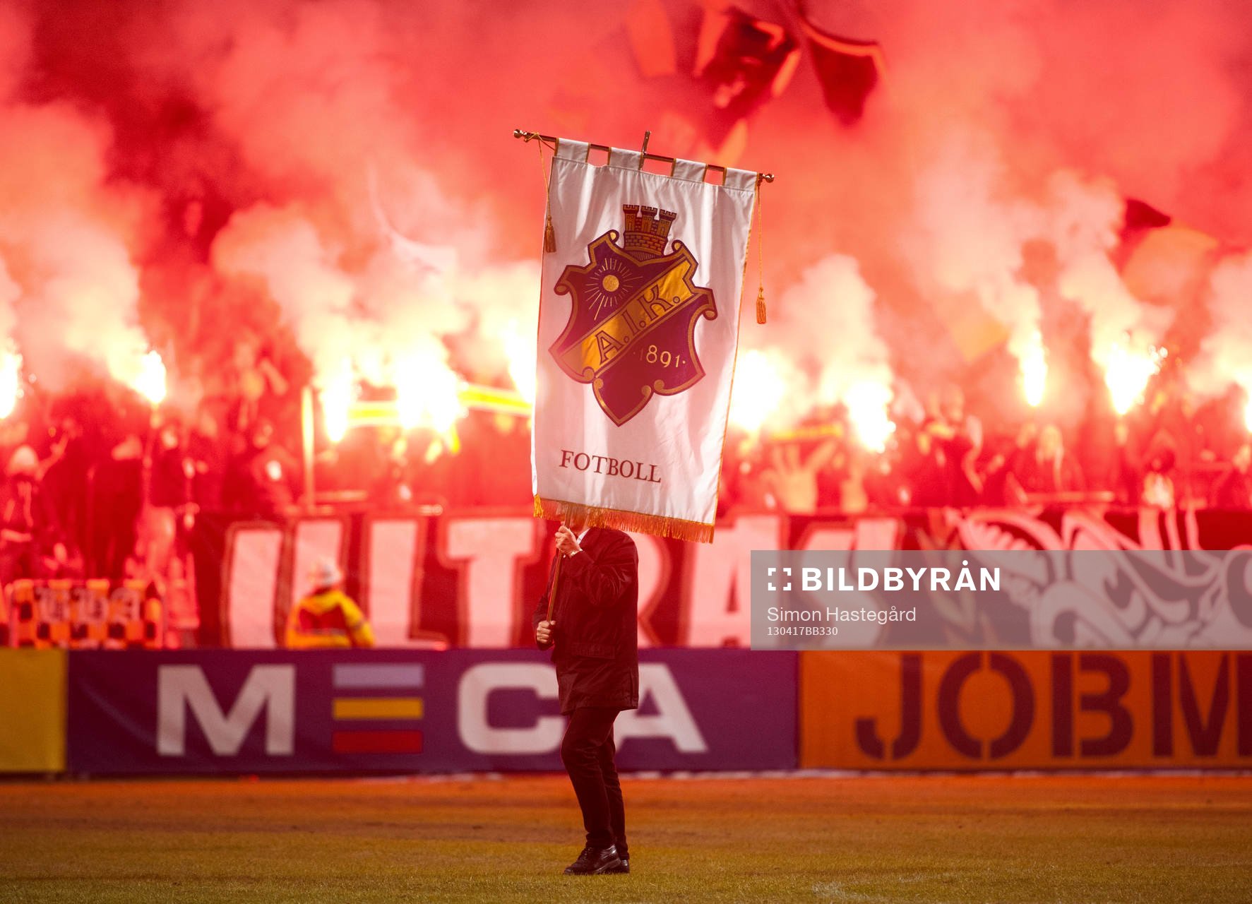 Man med AIK-flagga går över planen