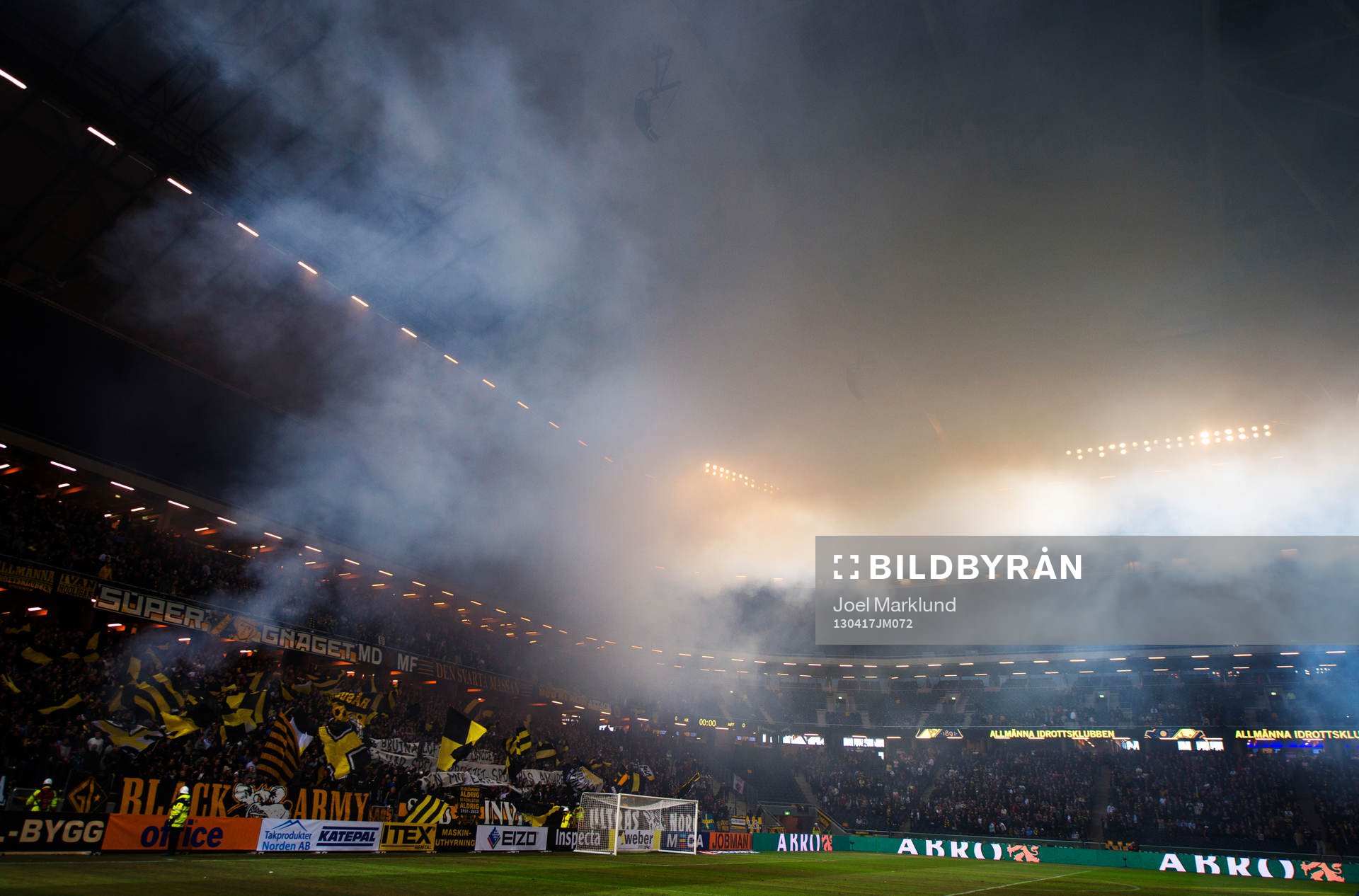 Rök från bengaleldar i AIK:s klack stiger mot taket i