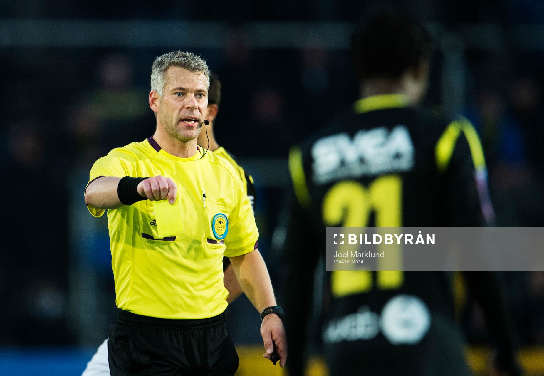 Tobias Mattsson, domare, delar ut ett gult kort