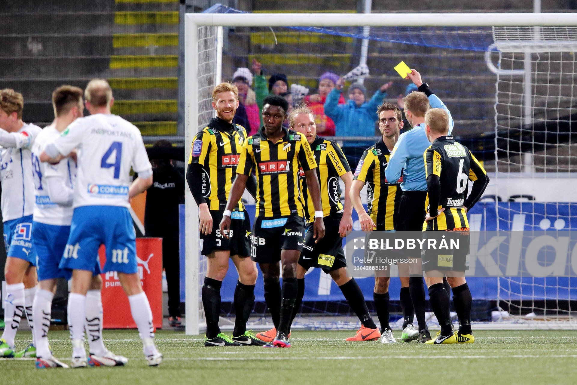 Johan Hamlin, domare, delar ut ett gult kort