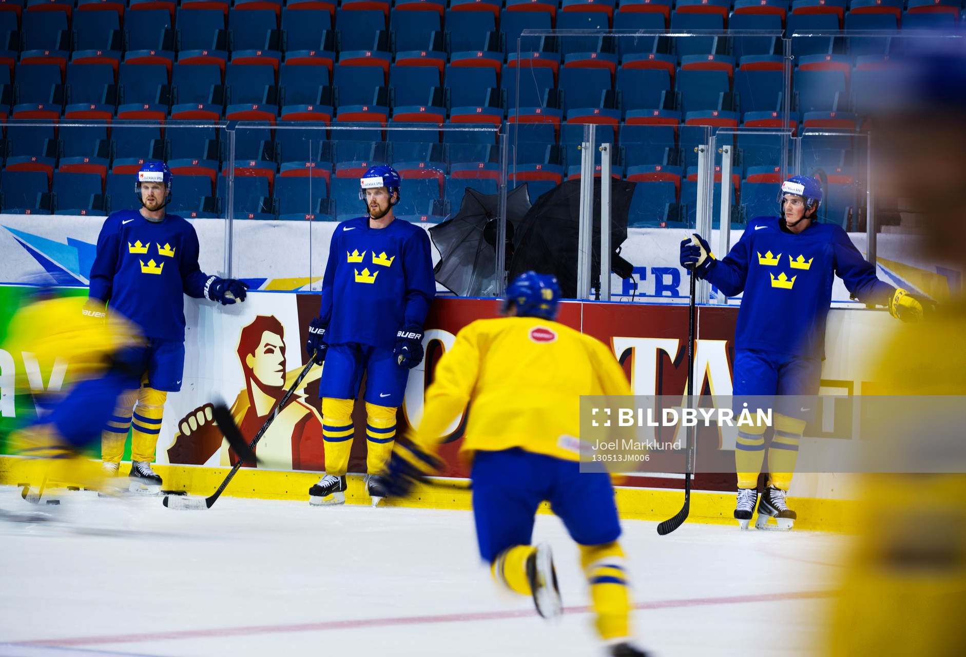 Spelare åker förbi Henrik Sedin, Daniel Sedin och Loui