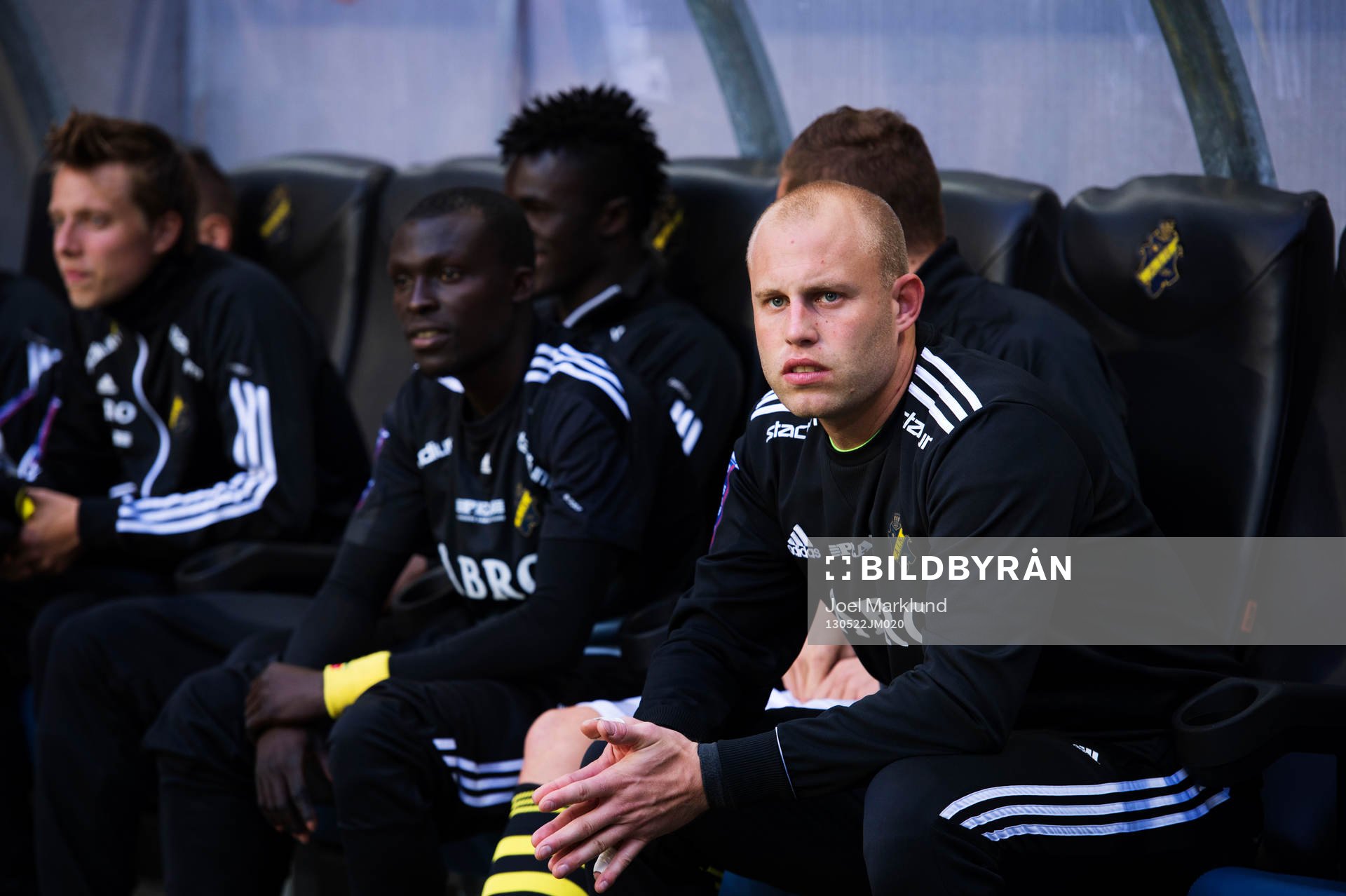 AIK:s nya målvakt Christian Frealdsson (h) sitter på läktaren i den allsvenska fotbollsmatchen mellan AIK och Djurgården 22 maj 2013 i Stockholm.