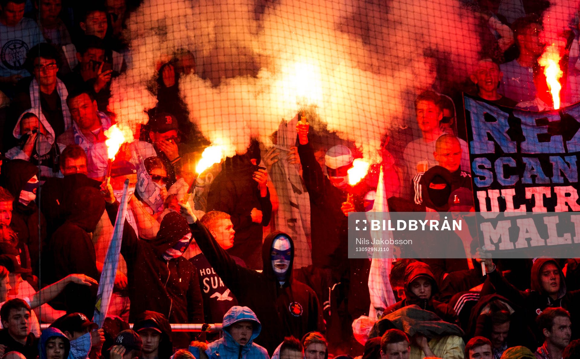 några maskerade personer tände en bengalisk eld