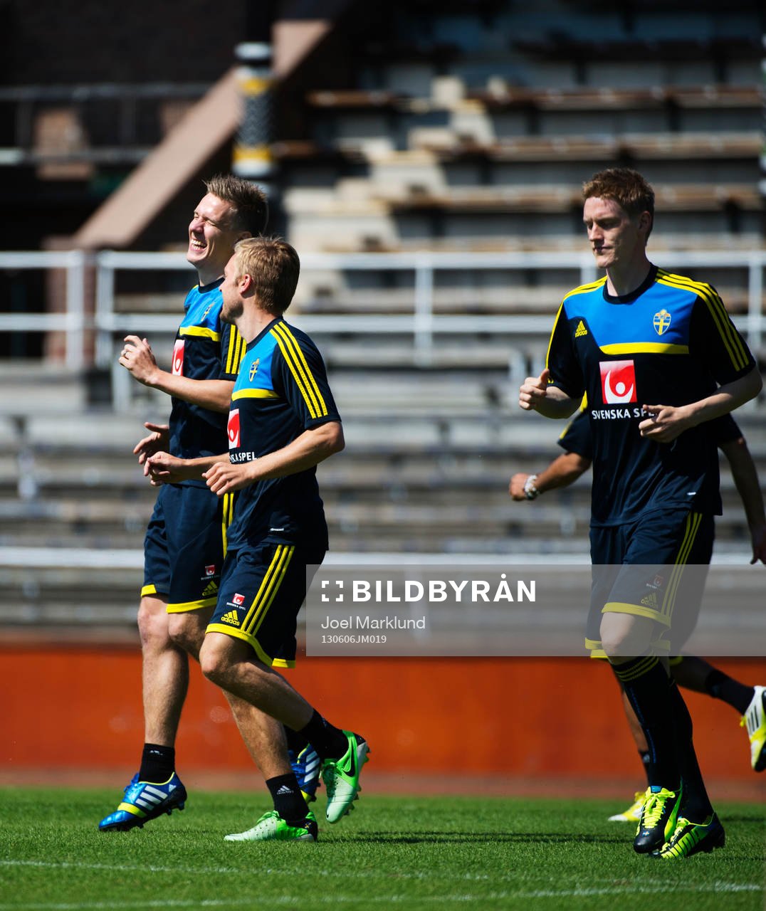 Pontus Wernbloom (v) och Sebastian Larsson (m) skrattar när de värmer upp på Sveriges träning 6 juni 2013 i Stockholm. Till höger är Rasmus Elm.