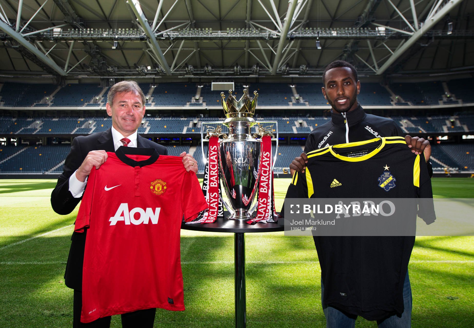 Bryan Robson och Henok Goitom poserar med matchtröjor under en presskonferens där det kommande mötet mellan fotbollslagen AIK och Manchester United presenterades 18 juni 2013 i Stockholm.