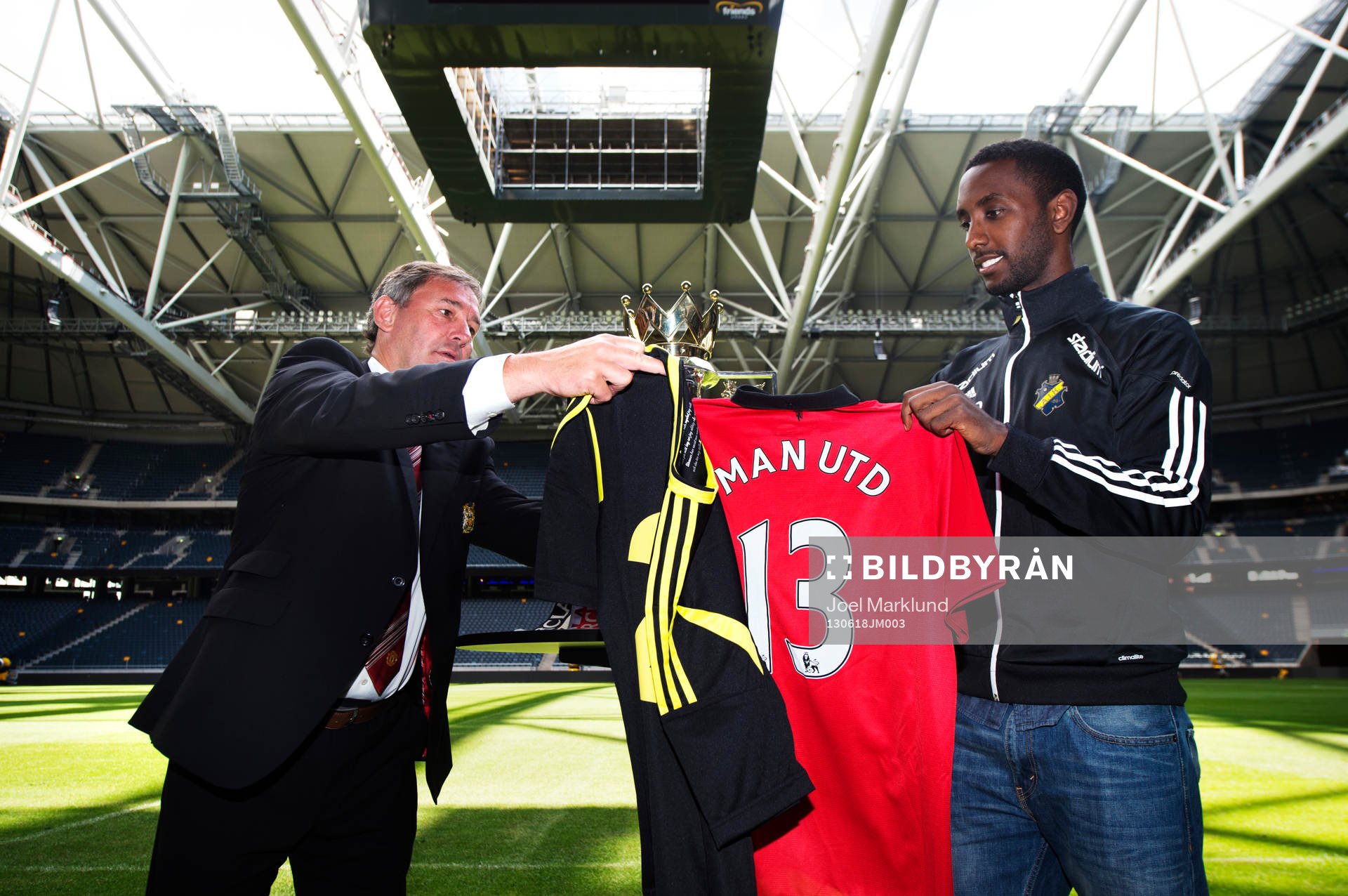 Bryan Robson och Henok Goitom byter matchtröjor med varandra under en presskonferens där det kommande mötet mellan fotbollslagen AIK och Manchester United presenterades 18 juni 2013 i Stockholm.
