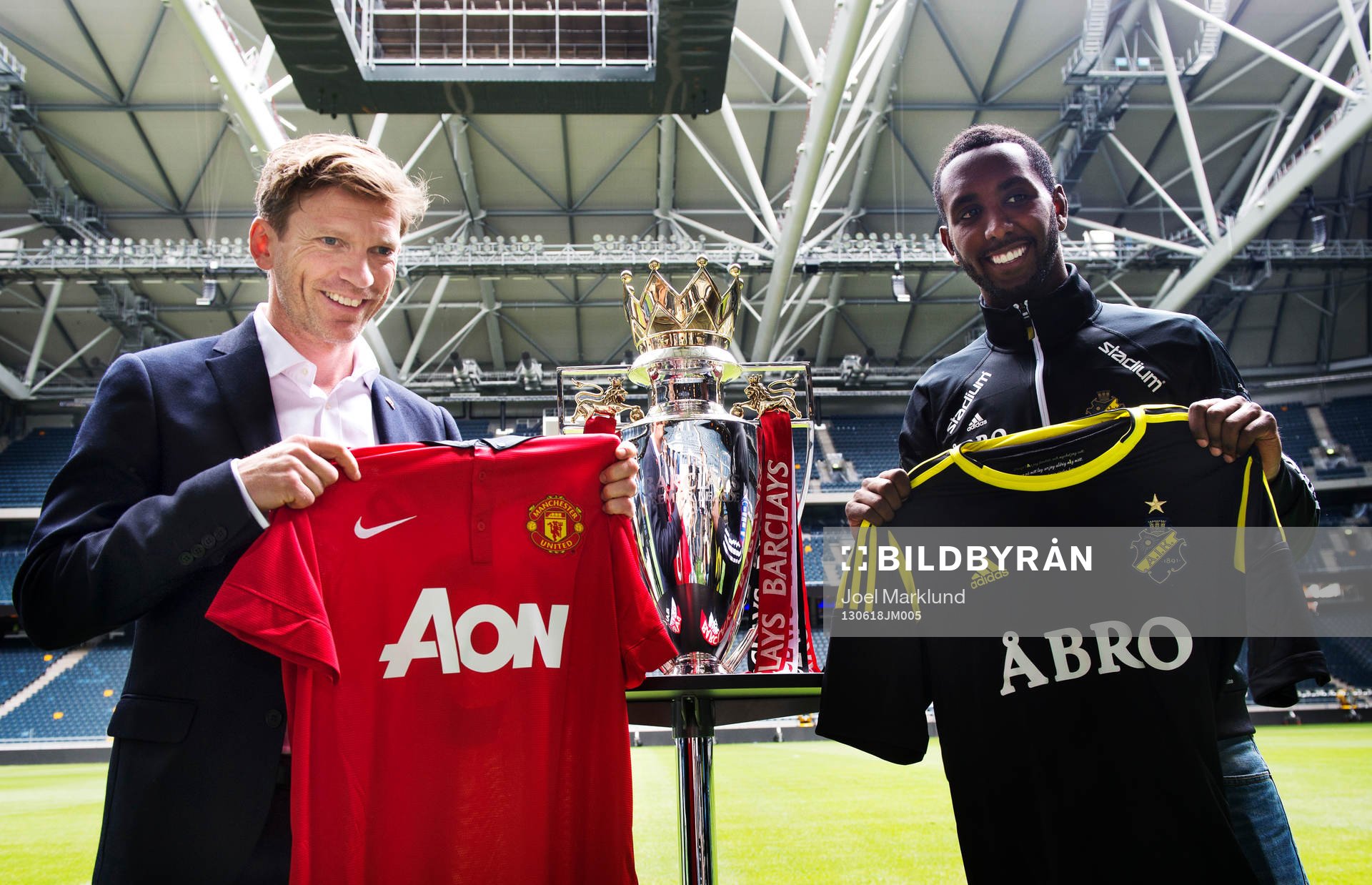 Jesper Blomqvist och Henok Goitom poserar med matchtröjor under en presskonferens där det kommande mötet mellan fotbollslagen AIK och Manchester United presenterades 18 juni 2013 i Stockholm.