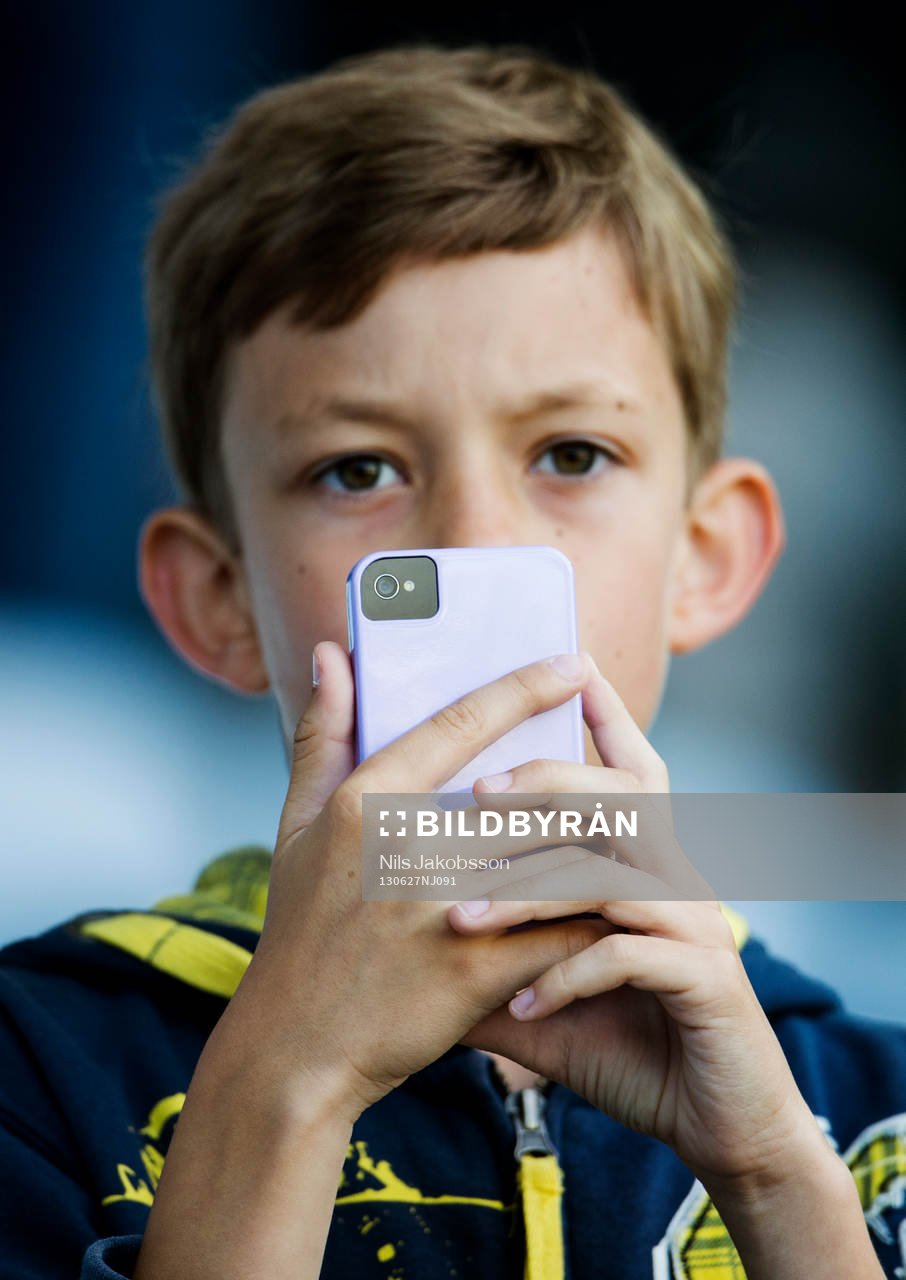En pojke fotar med sin iPhone