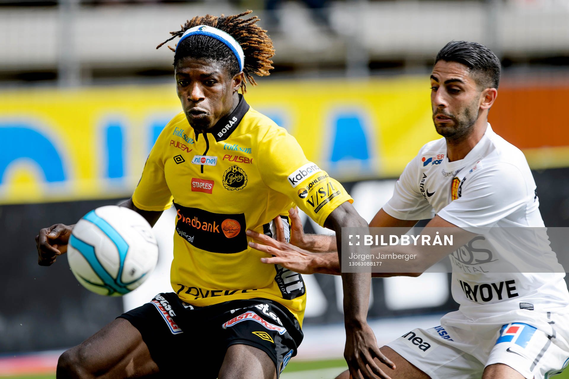 Elfsborgs Mohamed Bangura fokus på bollen och uppvaktas av Syrianskas Isa Demir i matchen mellan Elfsborg och Syrianska i Allsvenskan i fotboll 30 juni 2013 i Borås.