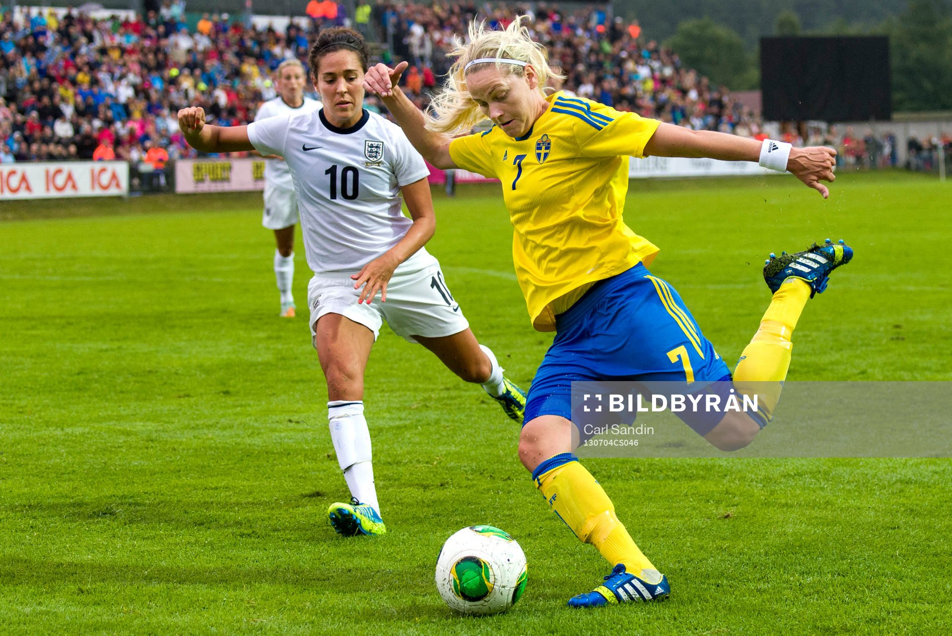 Sveriges Lisa Dahlkvist (h) laddar för skott framför Englands Fara Williams (v) under träningslandskampen mellan Sverige och England den 4 juli 2013 i Ljungskile.