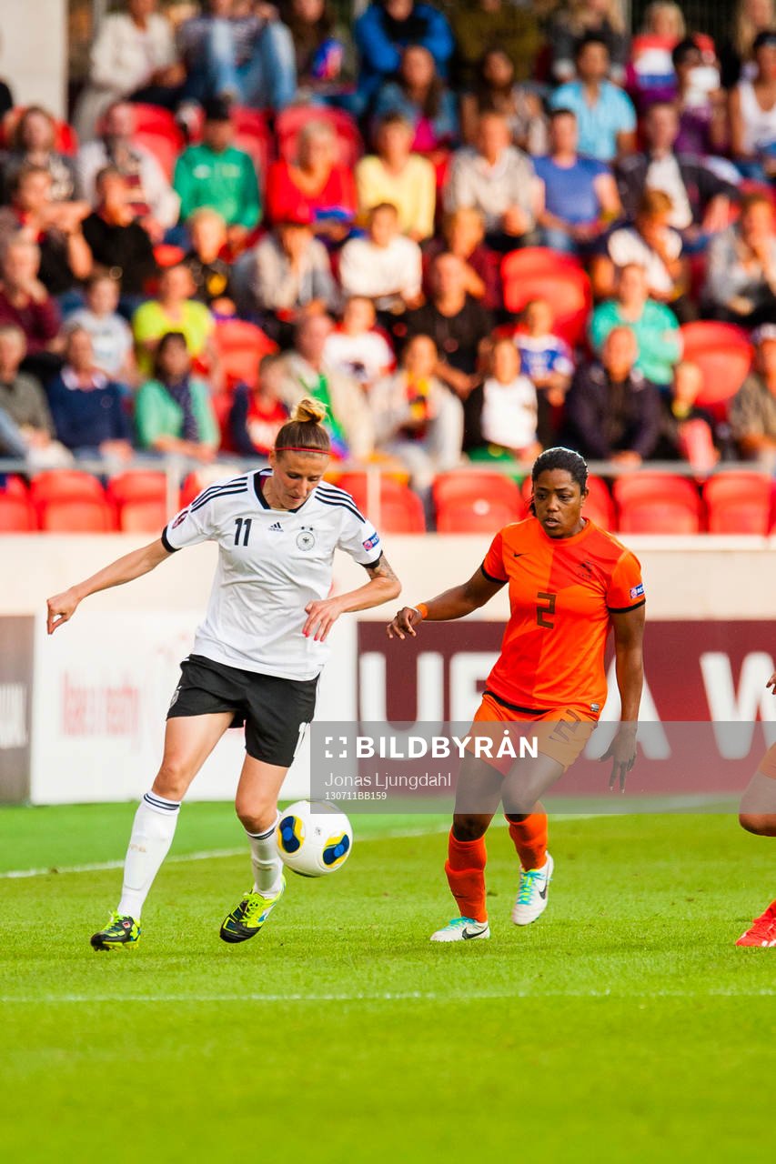 Tysklands Anja Mittag springer med bollen. Hollands Dyanne Bito jagar efter i matchen mellan Tyskland och Holland under dam-EM i fotboll 11 juli 2013 i Växjö