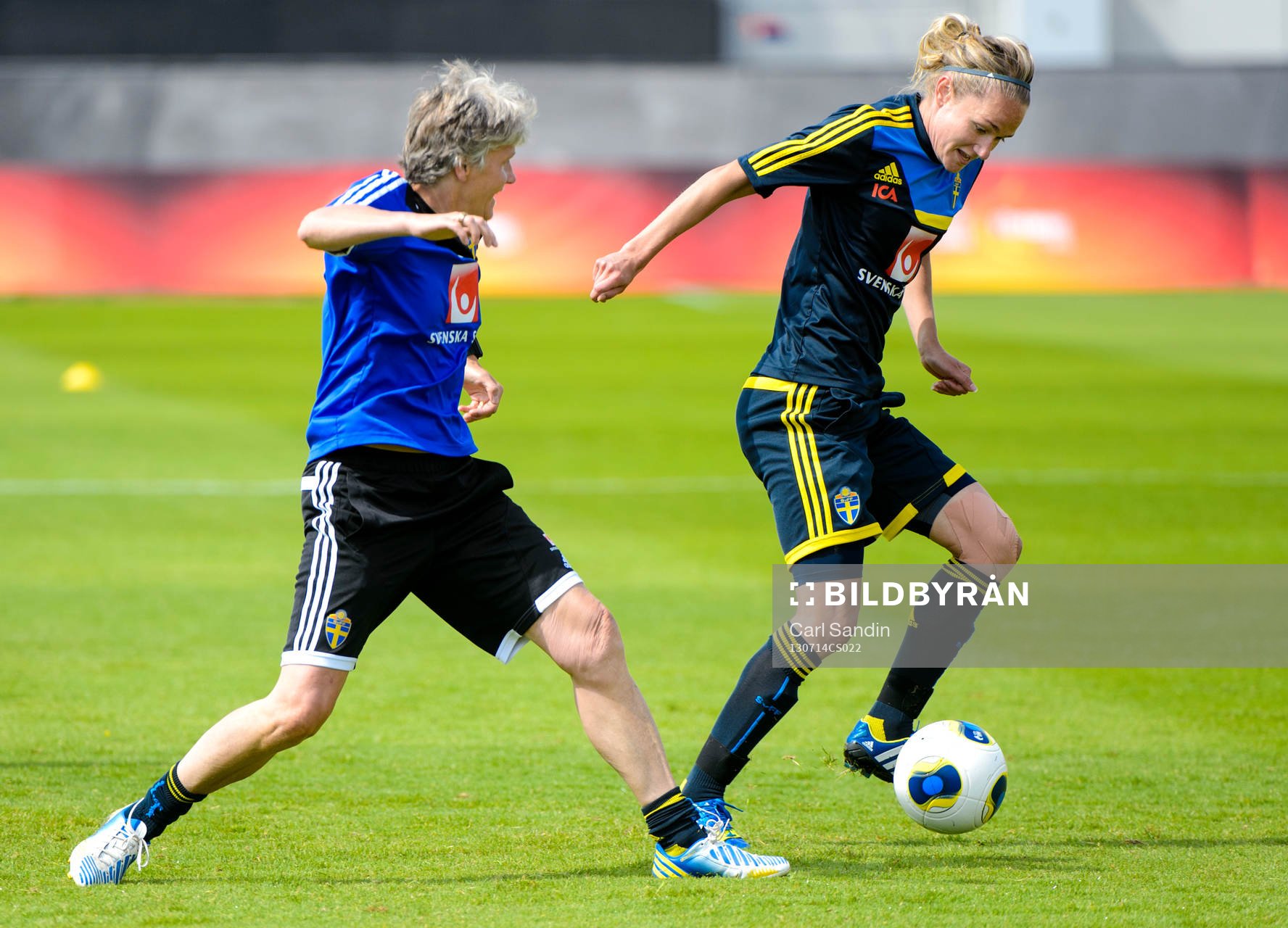 Sveriges förbundskapten Pia Sundhage i kamp om bollen med