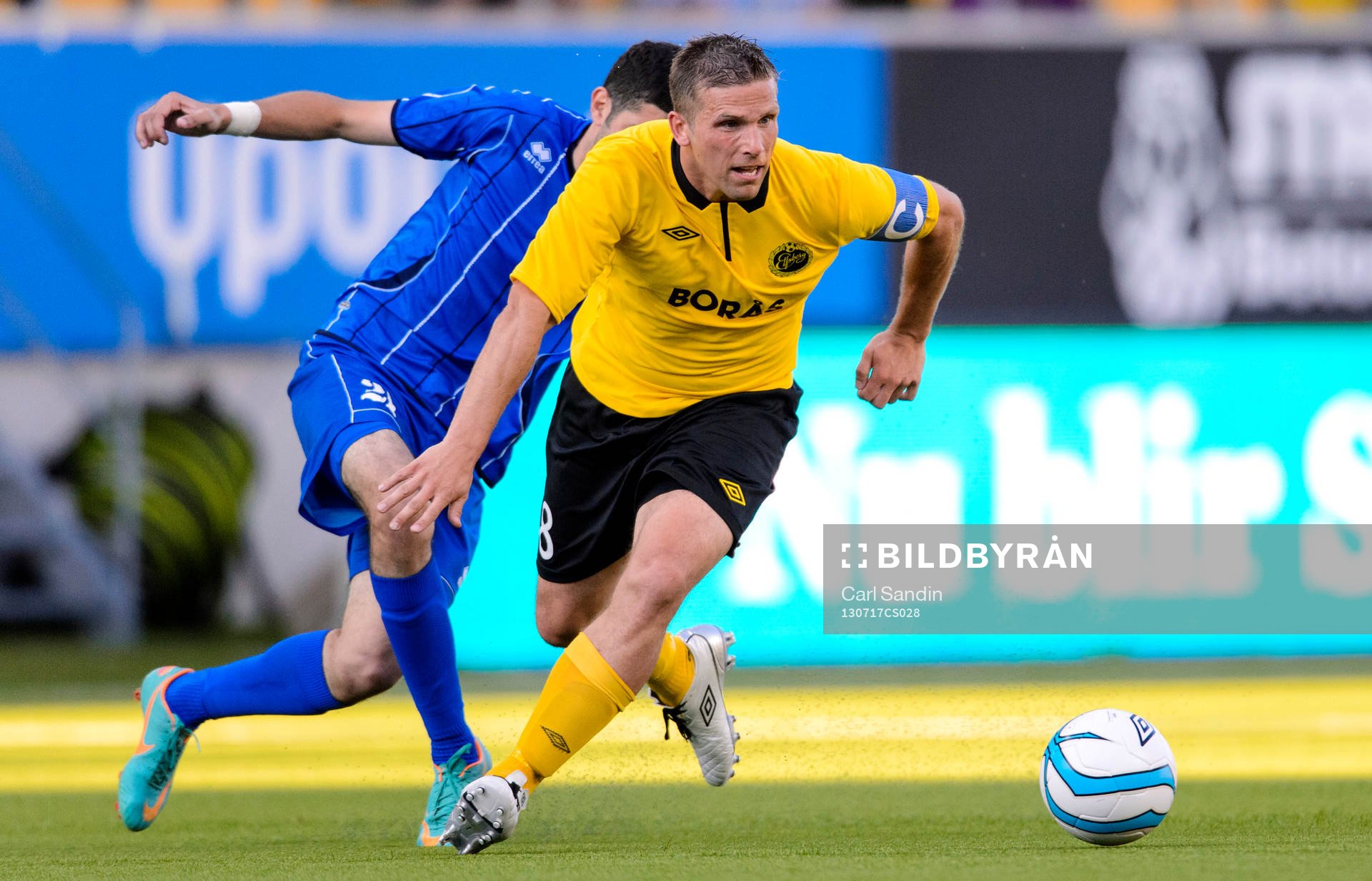 Elfsborgs Anders Svensson tar sig ur en närkamp med Daugavas Mamuka Gongadzde (dold) under matchen mellan Elfsborg och Daugava i kvalet till Champions League 17 juli 2013 i Borås.