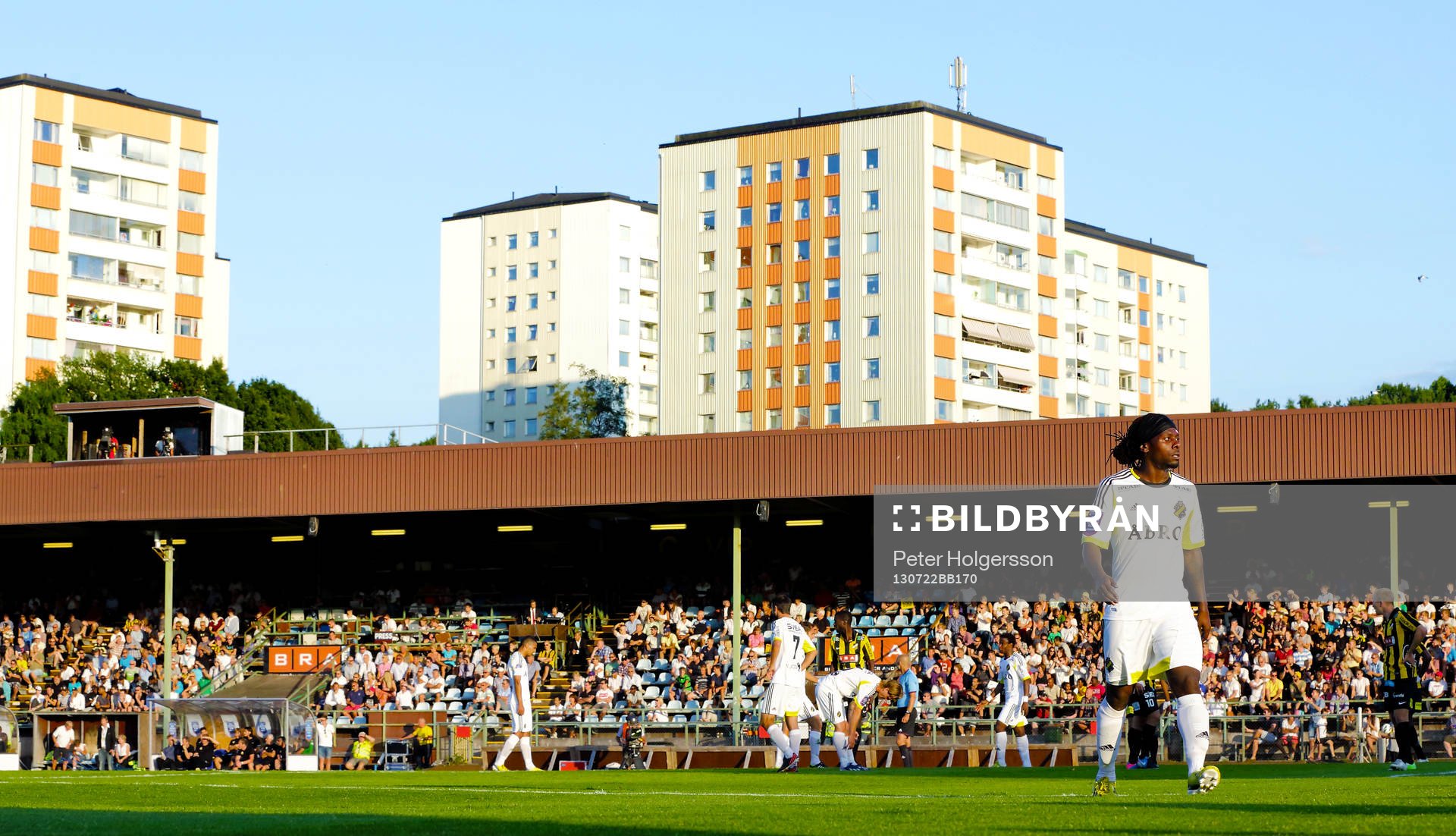s AIK:s Martin Kayongo Mutumba nedanför höghusen på