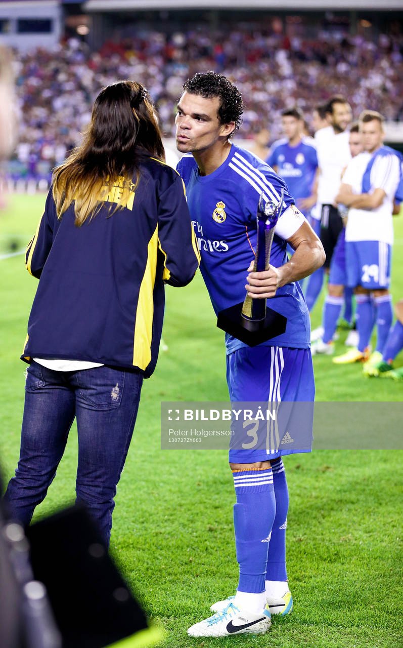 Real Madrids Pepe får troffén av Lotta Schelin under matchen mellan Real Madrid och Paris Saint-Germain 27 juli 2013 i Göteborg.