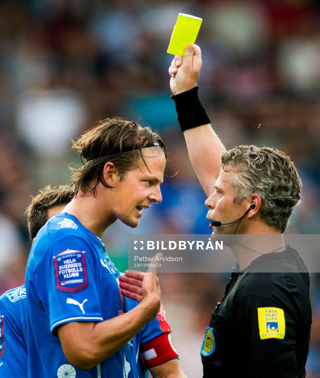 Halmstads Fredrik Liverstam får gult kort av domare Tobias Mattsson från Karlstad i fotbollsmatchen i Allsvenskan mellan Halmstad och Syrianska den 29 juli 2013 i Halmstad.