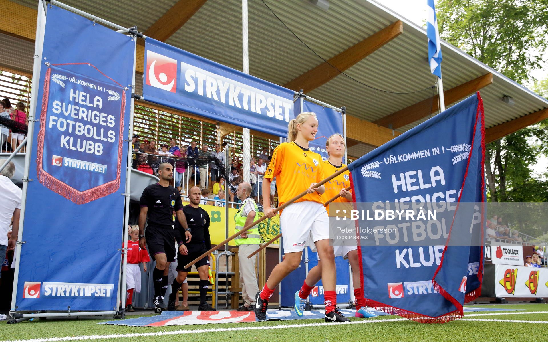 Intåg med Svenska spels fanor i fotbollsmatchen mellan