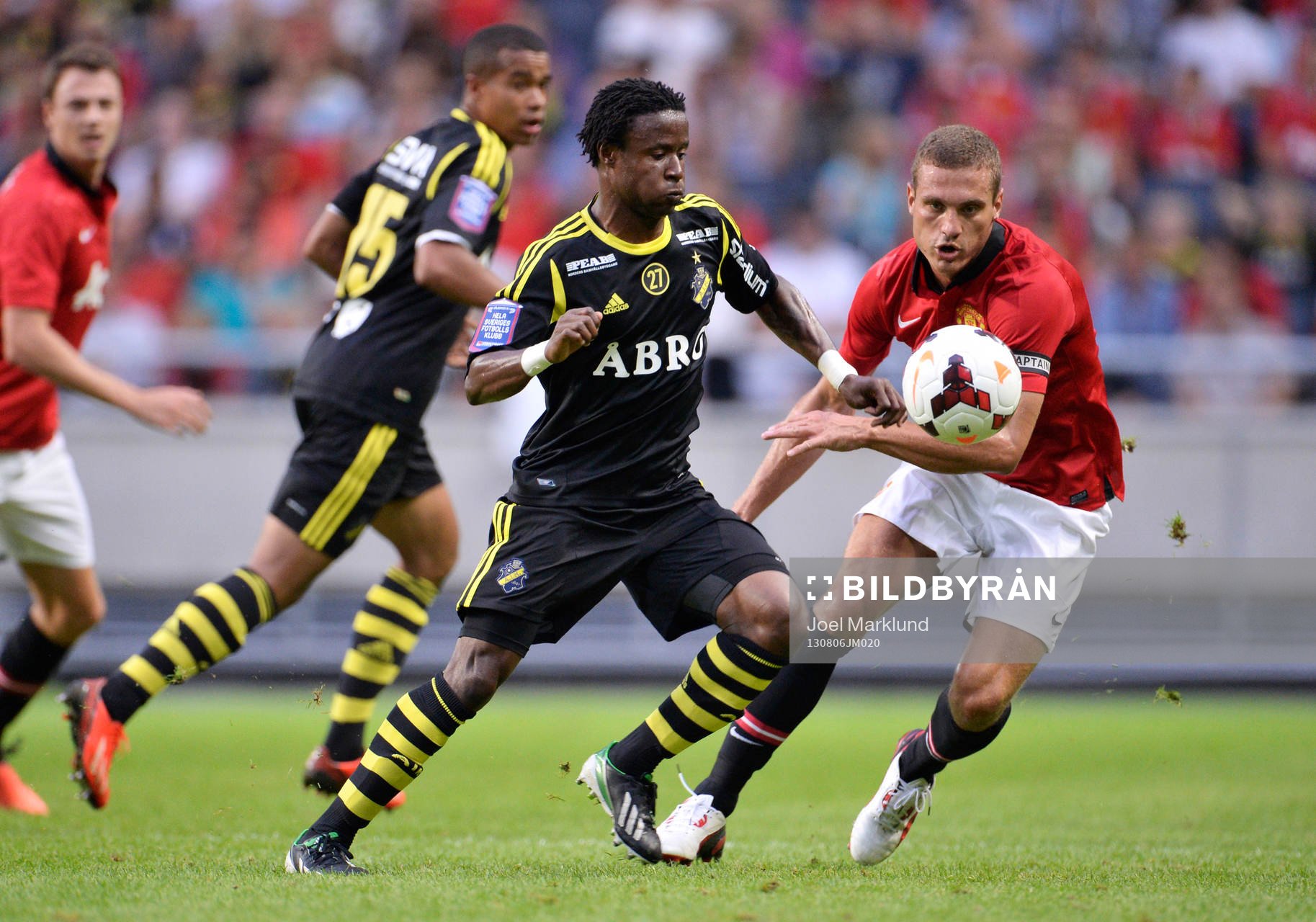 AIK:s Kennedy Igboananike utmanas av Manchester Uniteds Nemanja Vidic under fotbollsmatchen mellan AIK och Manchester United den 6 augusti 2013 i Stockholm.