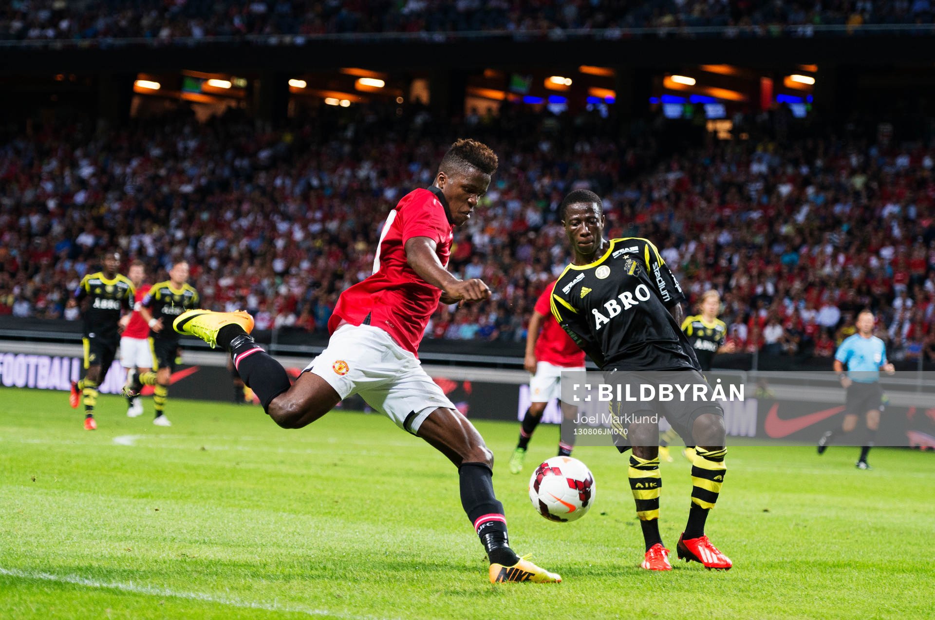 Manchester Uniteds Wilfried Zaha utmanar AIK:s Ebenezer Ofori under fotbollsmatchen mellan AIK och Manchester United den 6 augusti 2013 i Stockholm.