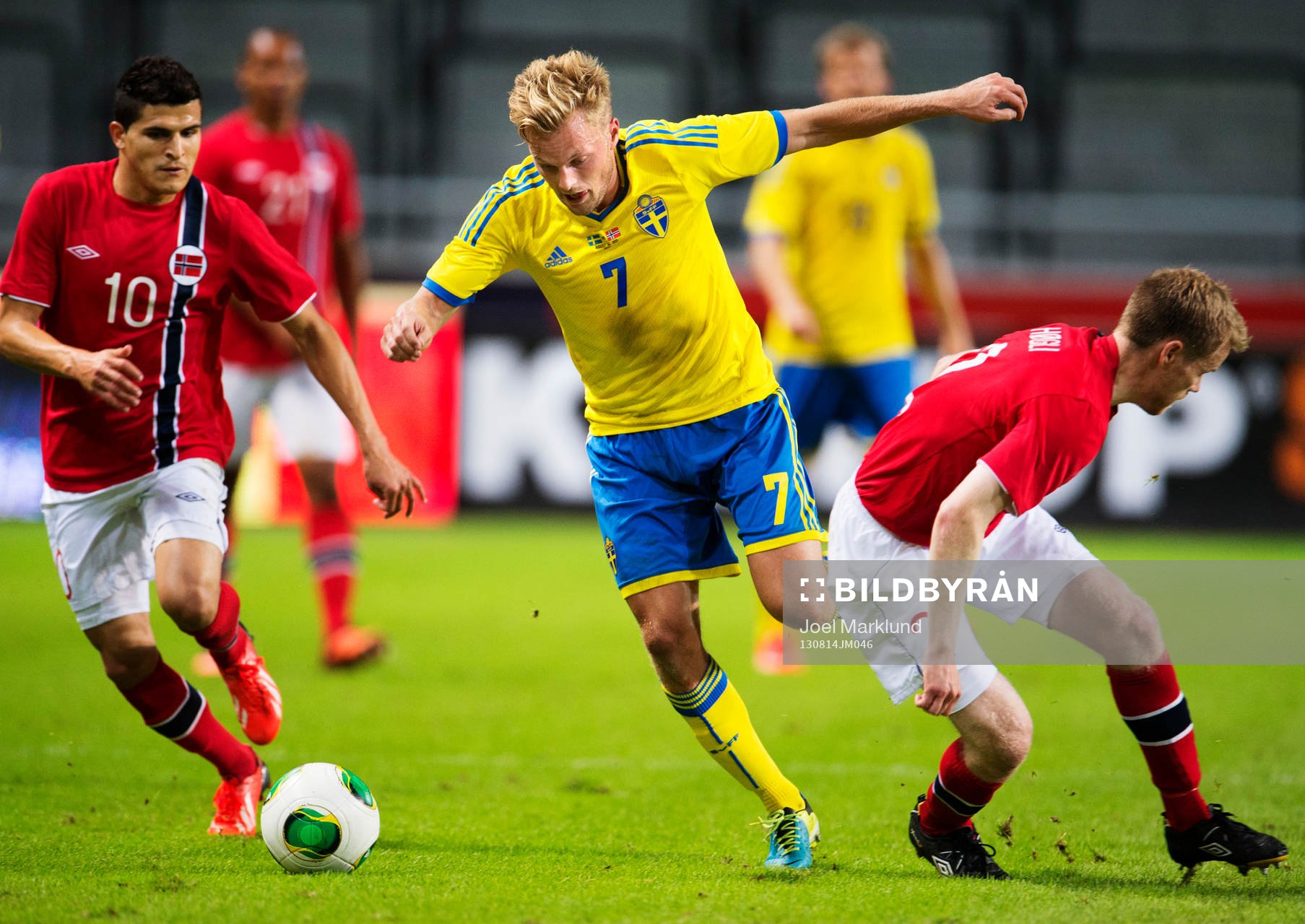 Norges Tarik Elyounoussi (v) och Tom Høgli (h) utmanas av Sveriges Sebastian Larsson (m) under träningslandskampen mellan Sverige och Norge den 14 augusti 2013 i Stockholm.