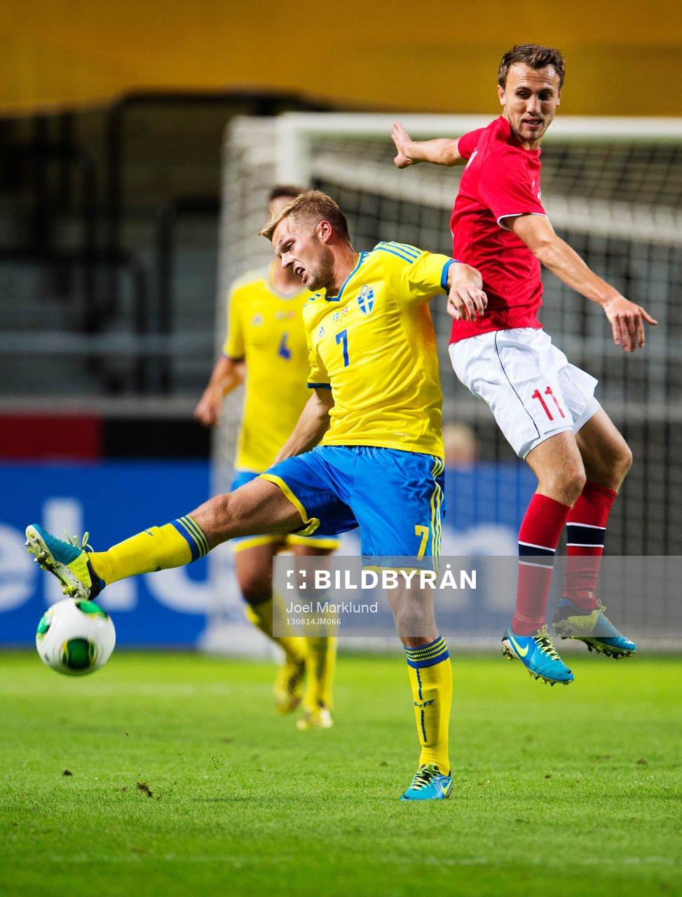 Sveriges Sebastian Larsson i en närkamp med Norges Magnus