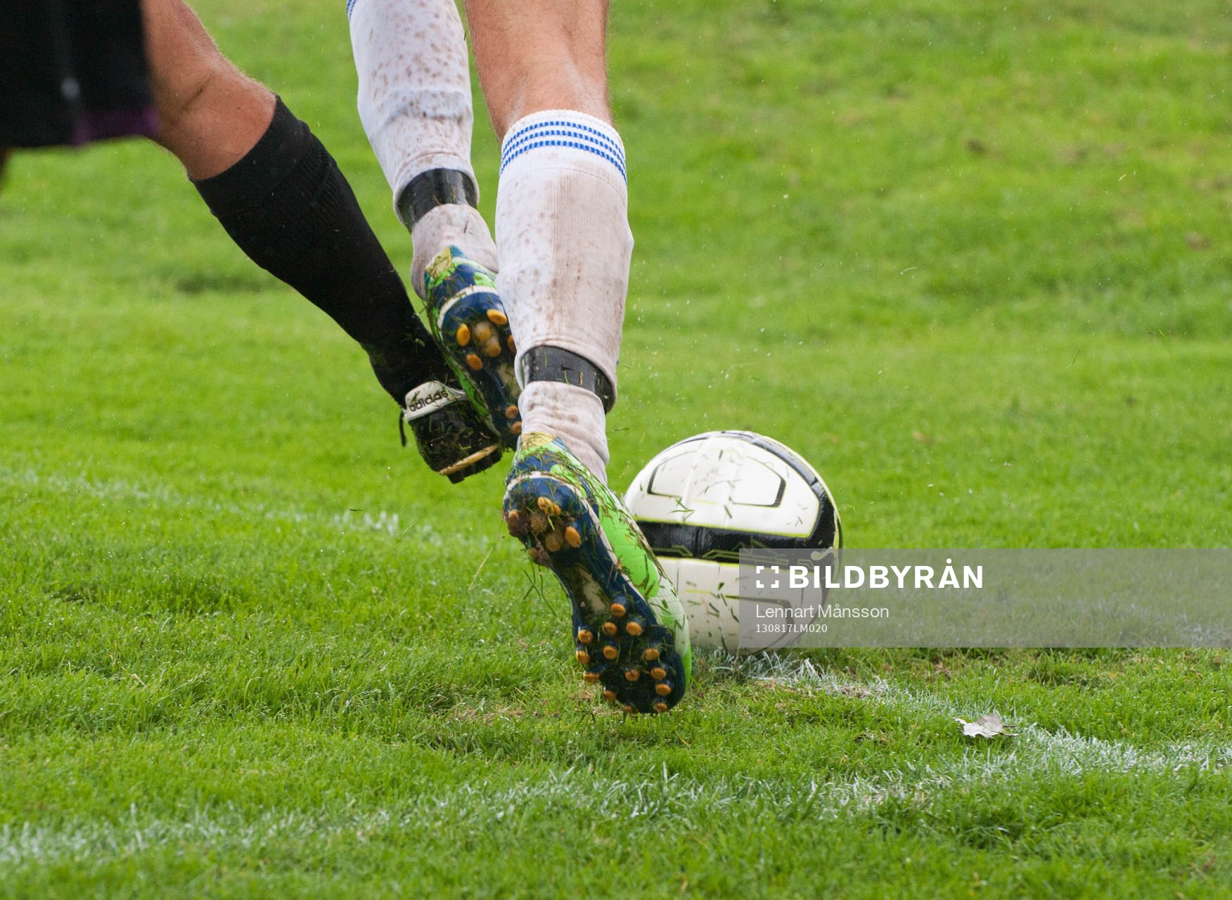 Fotboll, division 3, Hittarp - IFK Hässleholm: Kamp om bollen ute vid hörnflaggan, fot, fötter, fotboll, boll, fotbollsskor, fotbollsstrumpor. Tackling, spark på foten.
