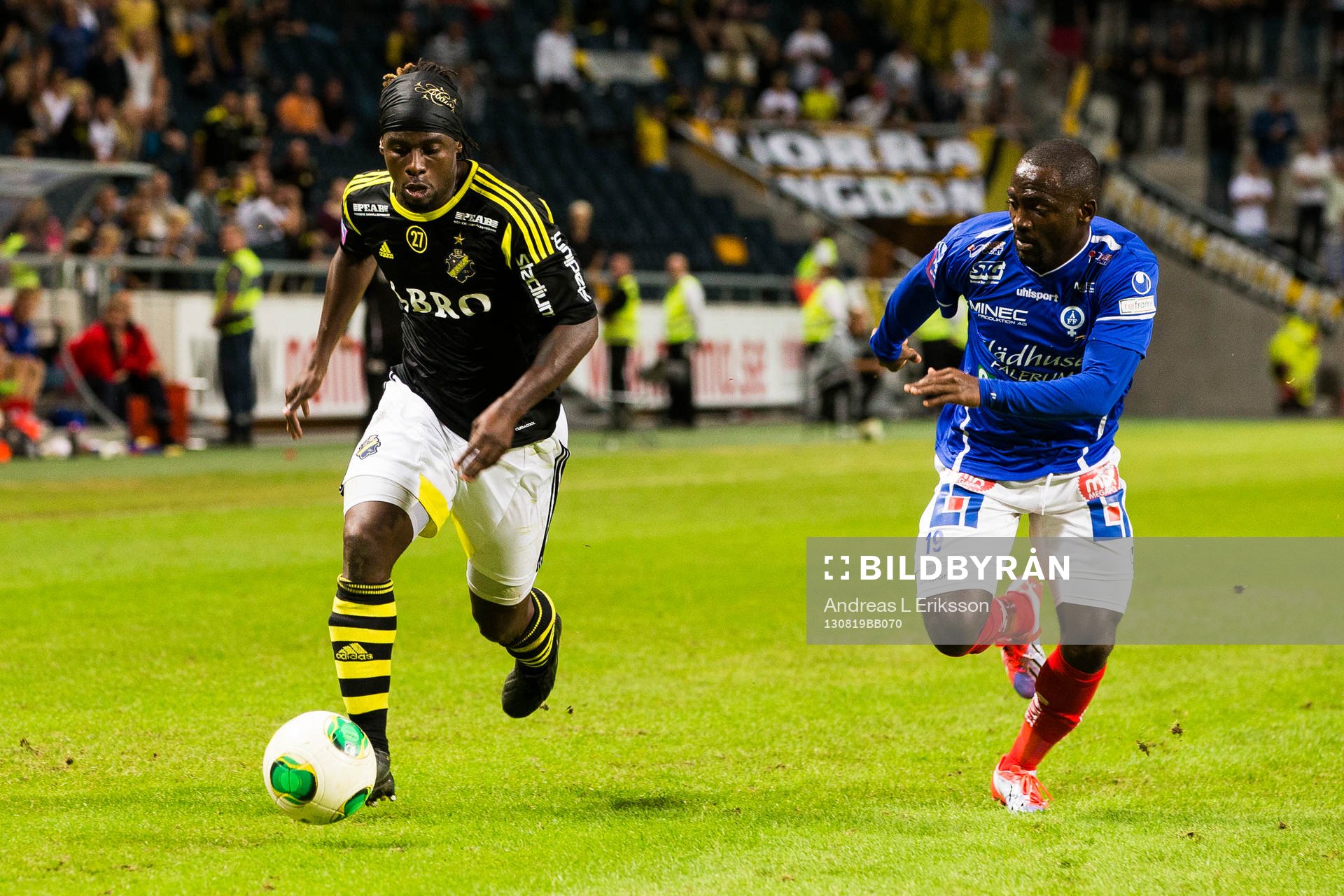 AIKs Martin Kayongo-Mutumba med bollen jagad av Åtvidabergs John Owoeri under fotbollsmatchen i Allsvenskan mellan AIK och Åtvidaberg den 19 augusti 2013 i Stockholm.