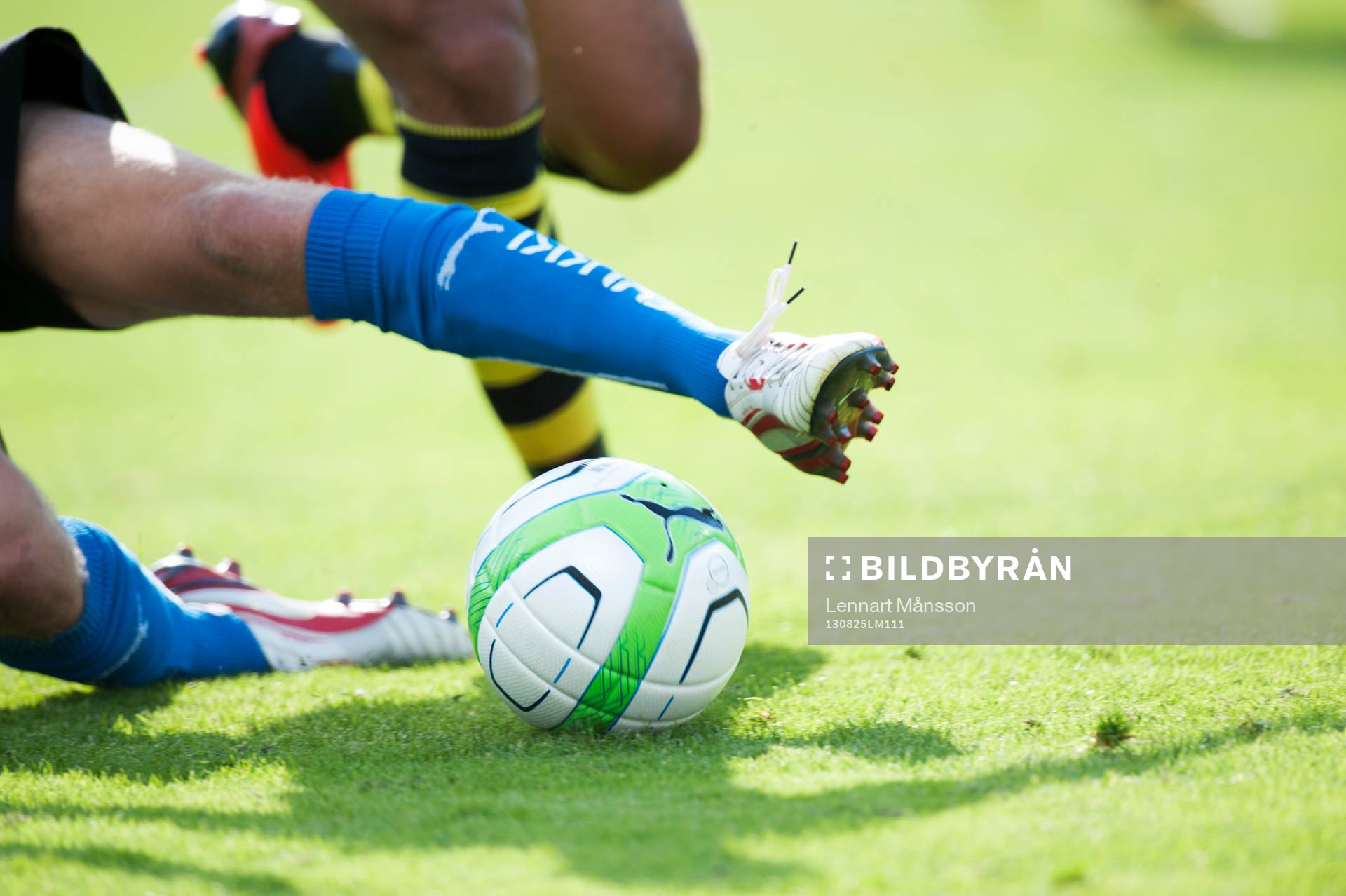 Fotboll, allsvenskan, Halmstad - AIK: Glidtackling, brytning, fot, fötter, boll, fotbollsskor, skugga, i den allsvenska matchen mellan Halmstad och AIK.