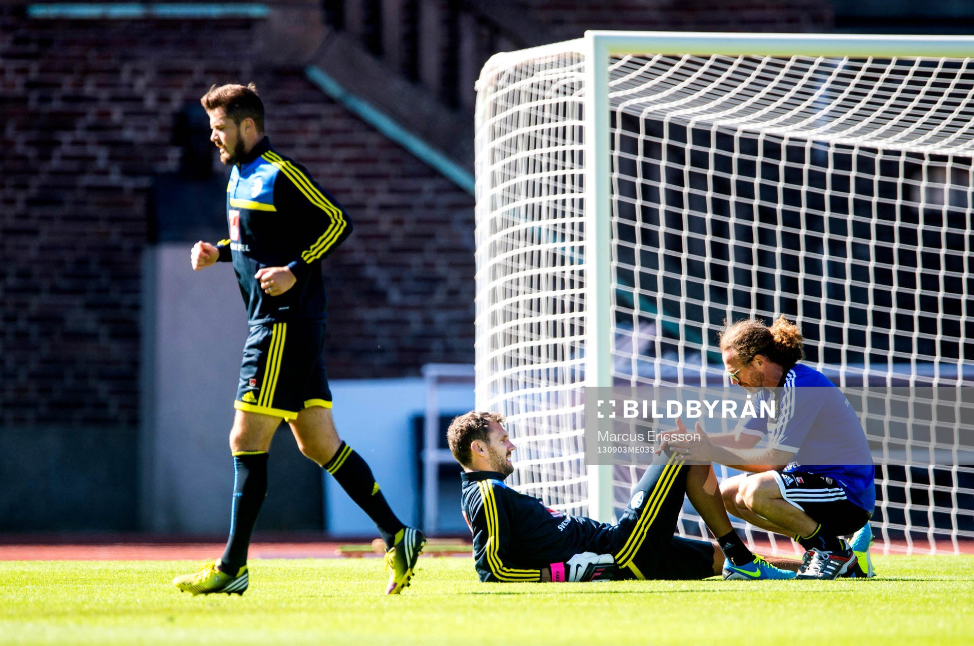 Sveriges Per Nilsson joggar runt medans Richard Dahan, sjukgymnast, tittar på Andreas Isaksson, målvakt under träningen på Stockholm Stadion den 3 september 2013 i Stockholm inför EM-kval matcherna i fotboll.
