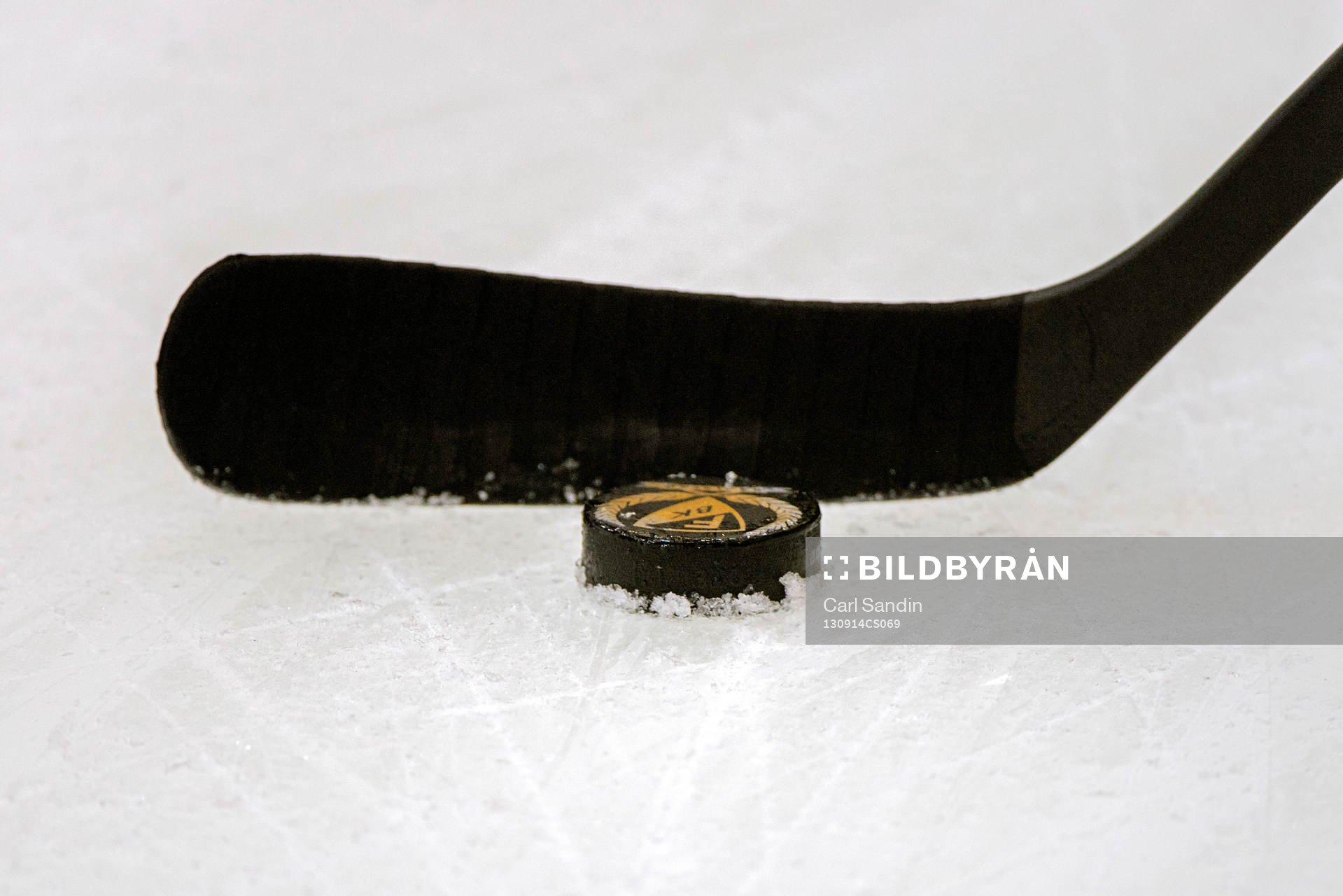 Ishockeyklubba med puck på isen