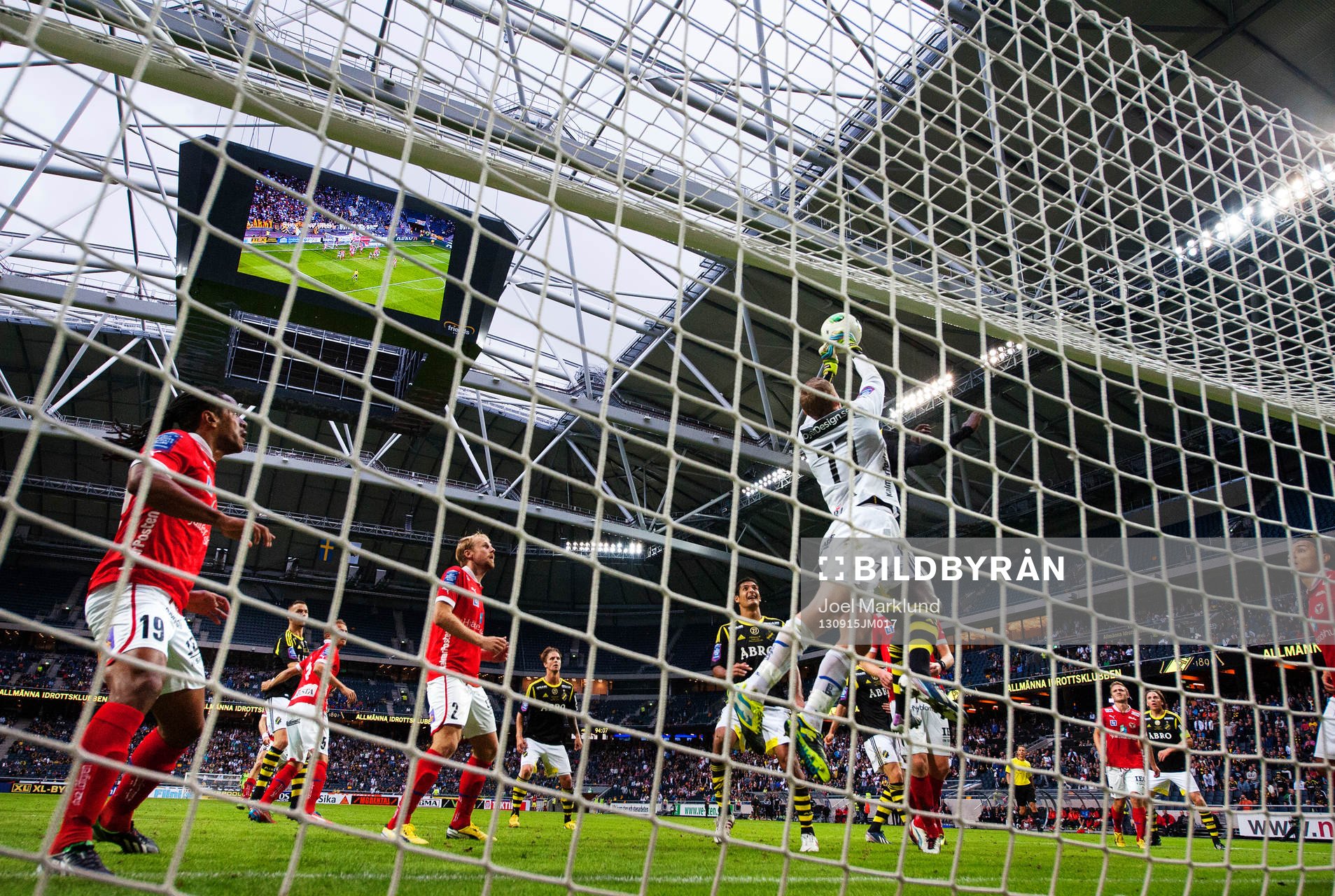Kalmars målvakt Lars Cramer boxar ut bollen i en duell med AIK:s Henok Goitom under fotbollsmatchen i Allsvenskan mellan AIK och Kalmar den 15 september 2013 i Stockholm.