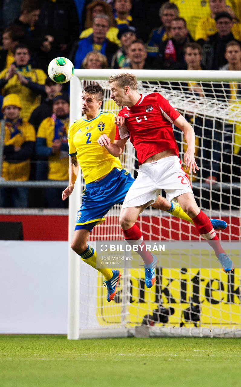 Sveriges Mikael Lustig i en luftduell med Österrikes Marc
