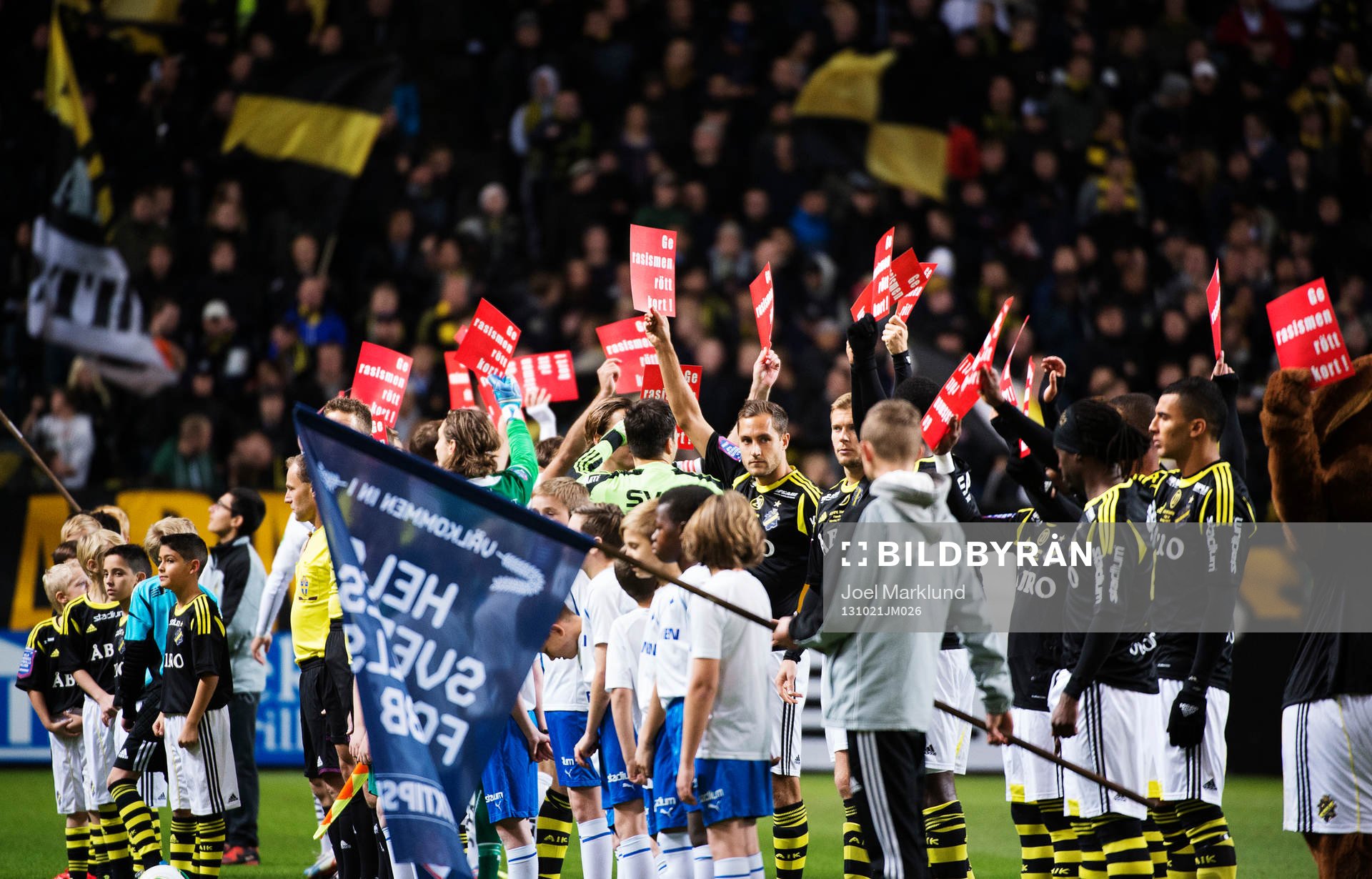 Spelare i båda lagen deltar i en manifestation mot rasism, Ge rasismen rött kort, under fotbollsmatchen i Allsvenskan mellan AIK och Norrköping den 21 oktober 2013 i Stockholm.