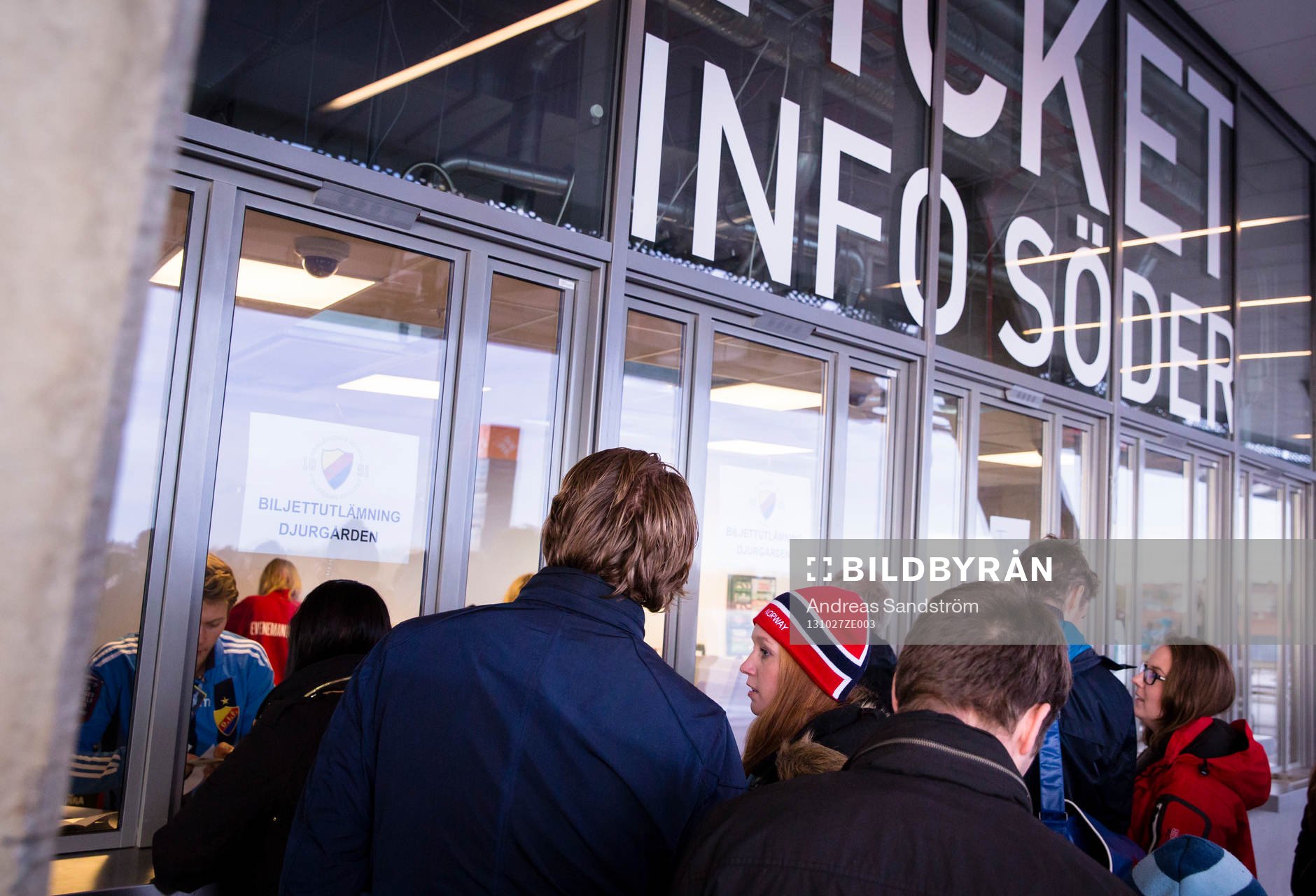 En kvinna med en Norsk mössa står vid biljettluckan.