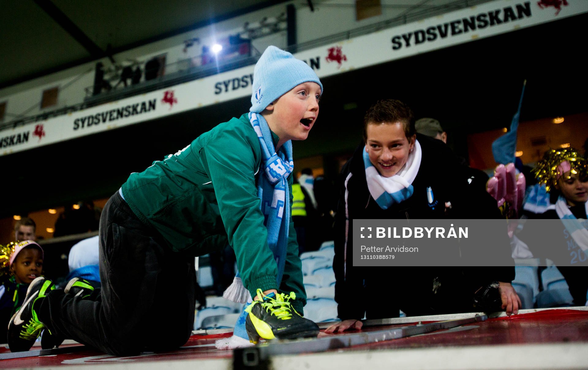 En ung Malmö supporter kryper uppe på spelarbänkens tak