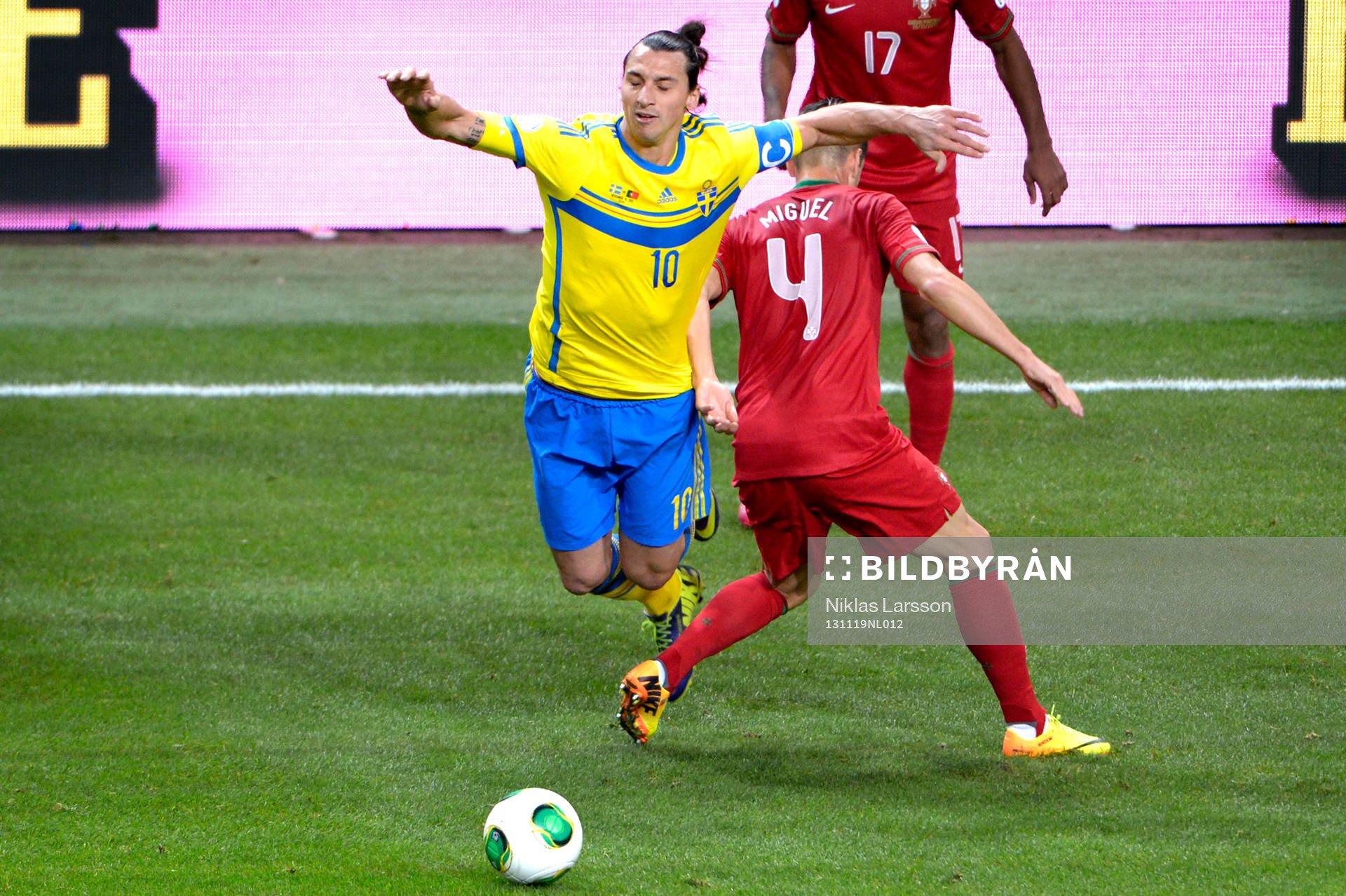 Sveriges Zlatan Ibrahimovic faller över Portugals Miguel Veloso under playoff-matchen i VM-kvalet mellan Sverige och Portugal den 19 november 2013 i Stockholm.