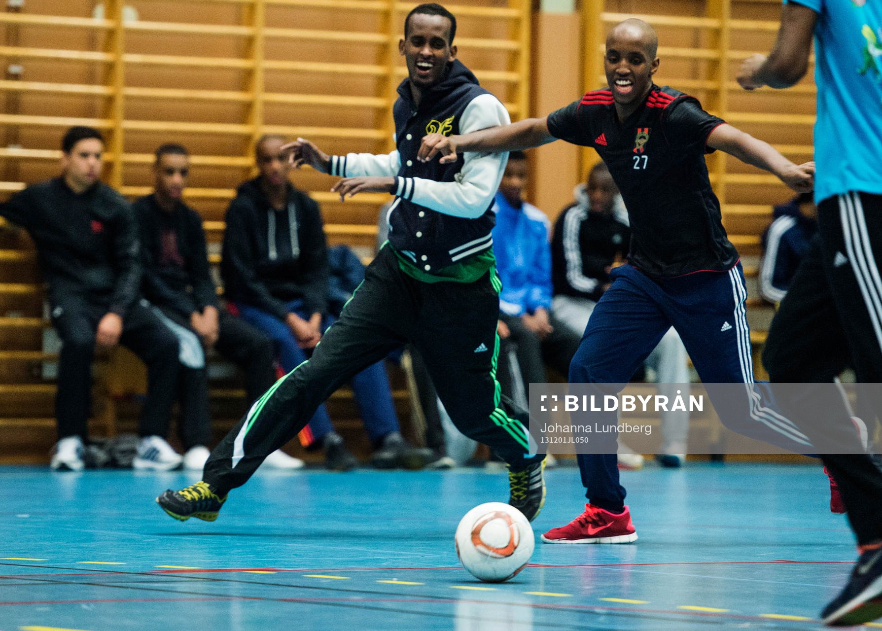Två killar skrattar i kamp om bollen