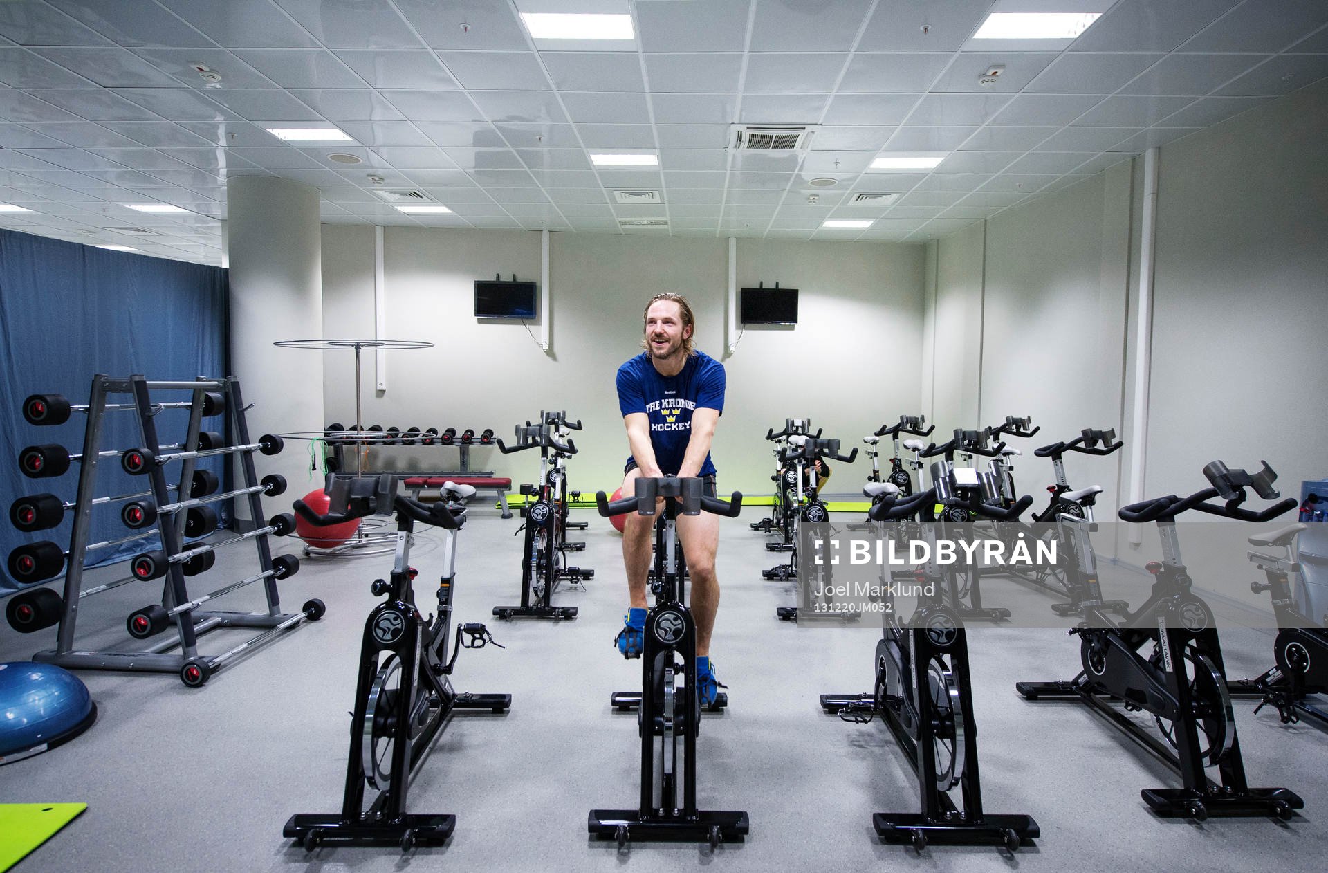Sveriges Niklas Persson cyklar i ett styrketräningsrum i