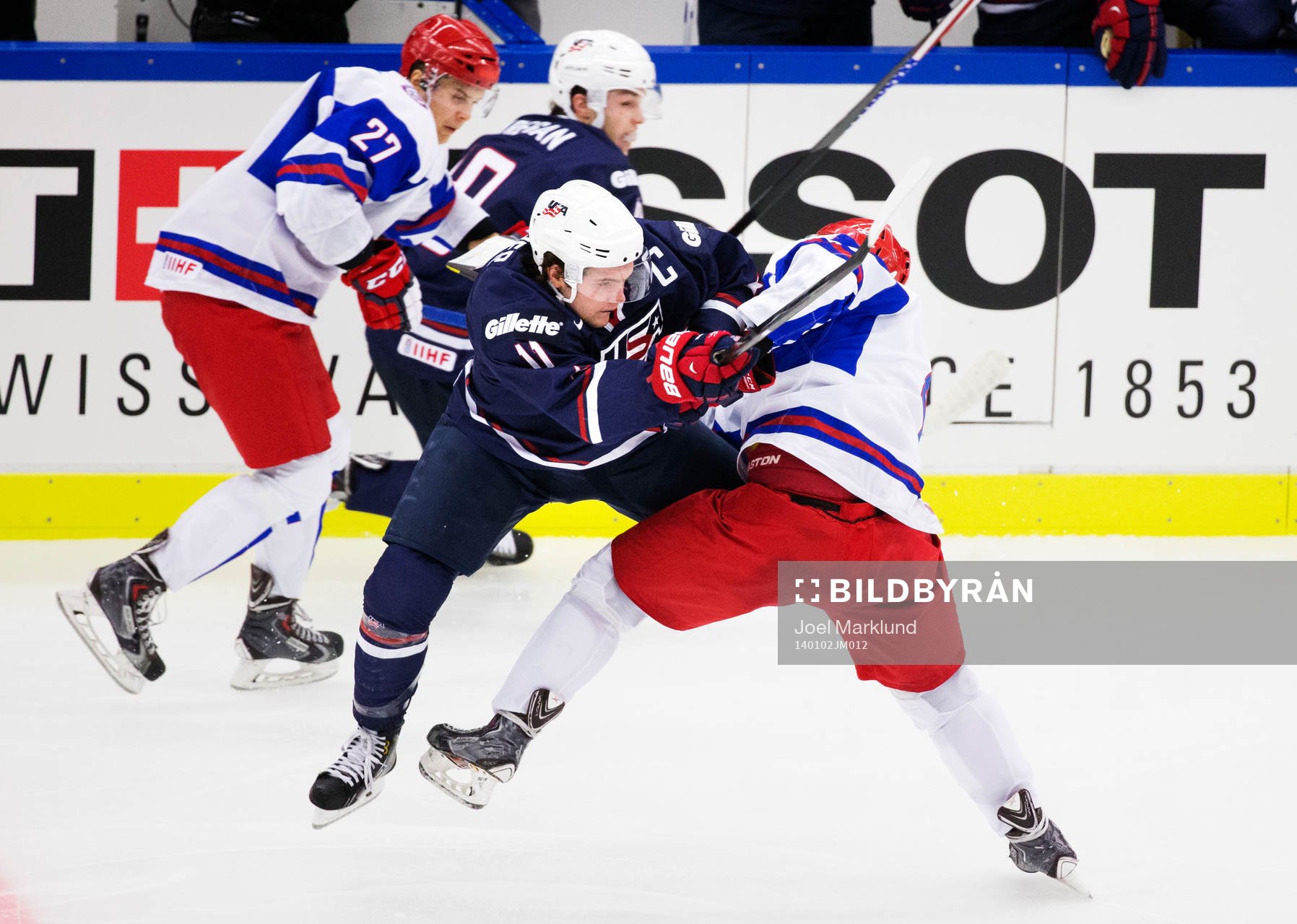 s Riley Barber tacklas av Rysslands Ilya Lyubushkin