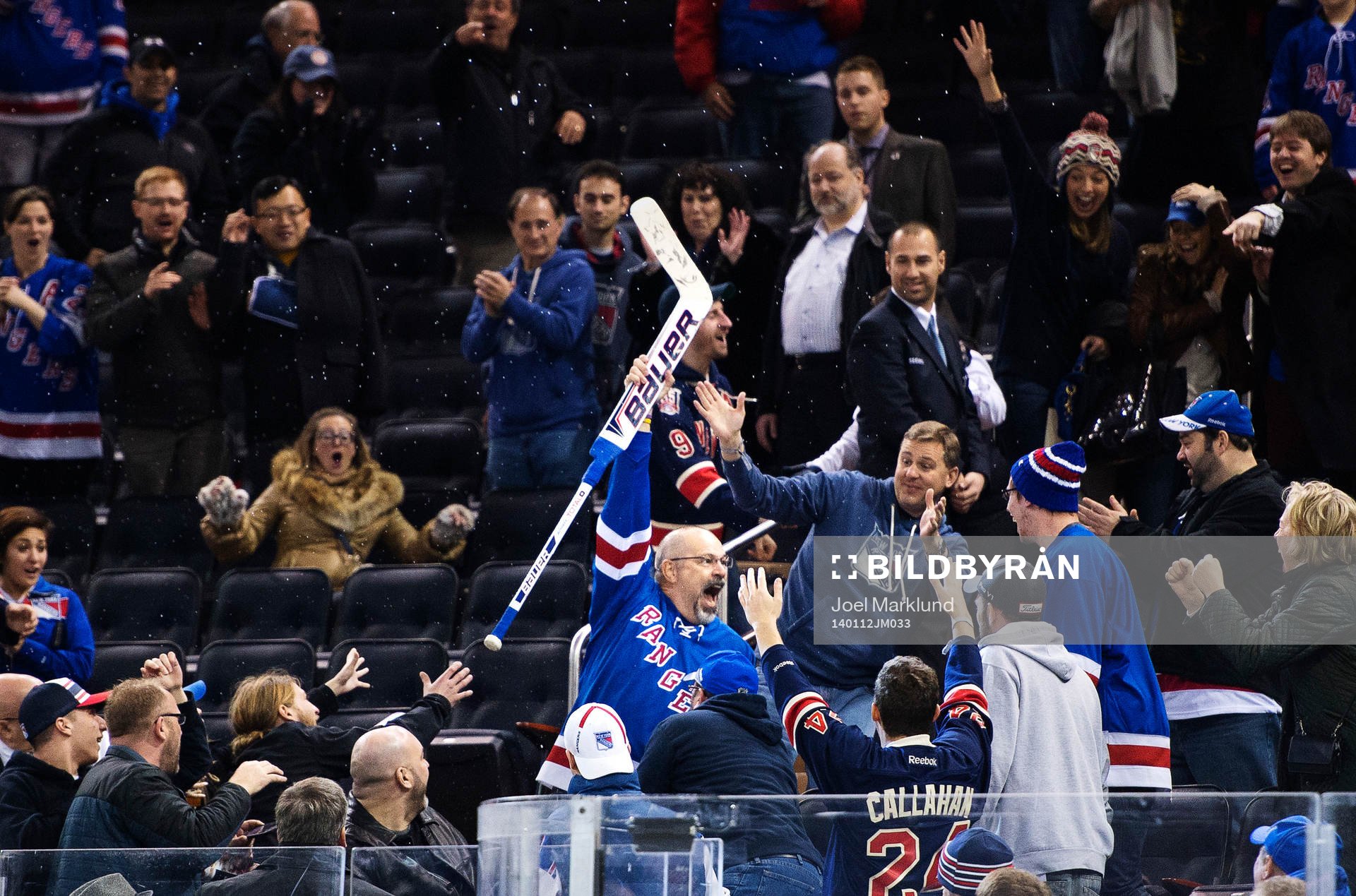 En man fångar en hockeyklubba som Henrik Lundqvist kastat