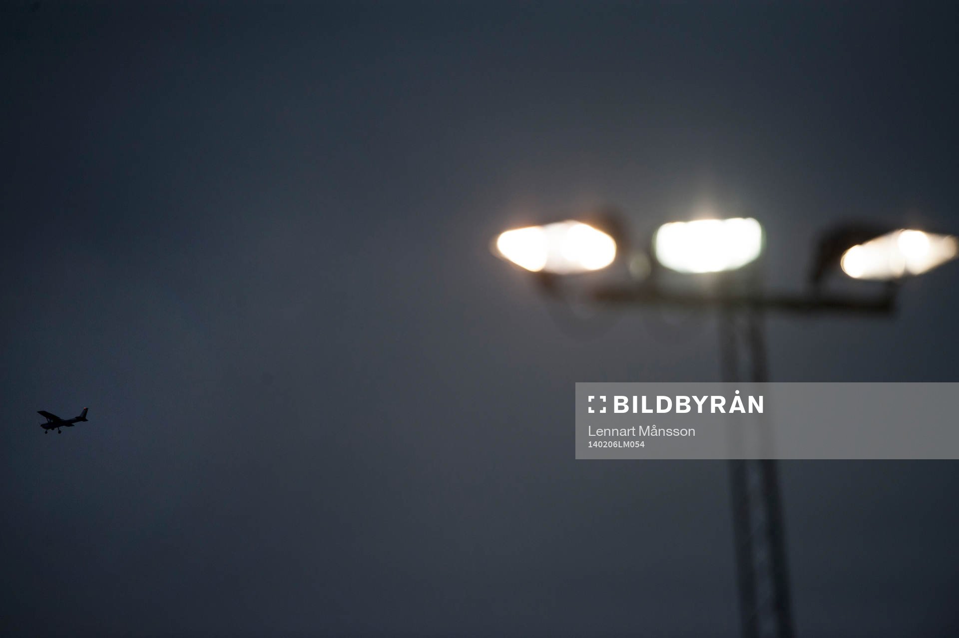 Ett flygplan passerar belysningsstolparna i träningsmatchen mellan Helsingborg och Odense i Helsingborg 6 februari 2014.