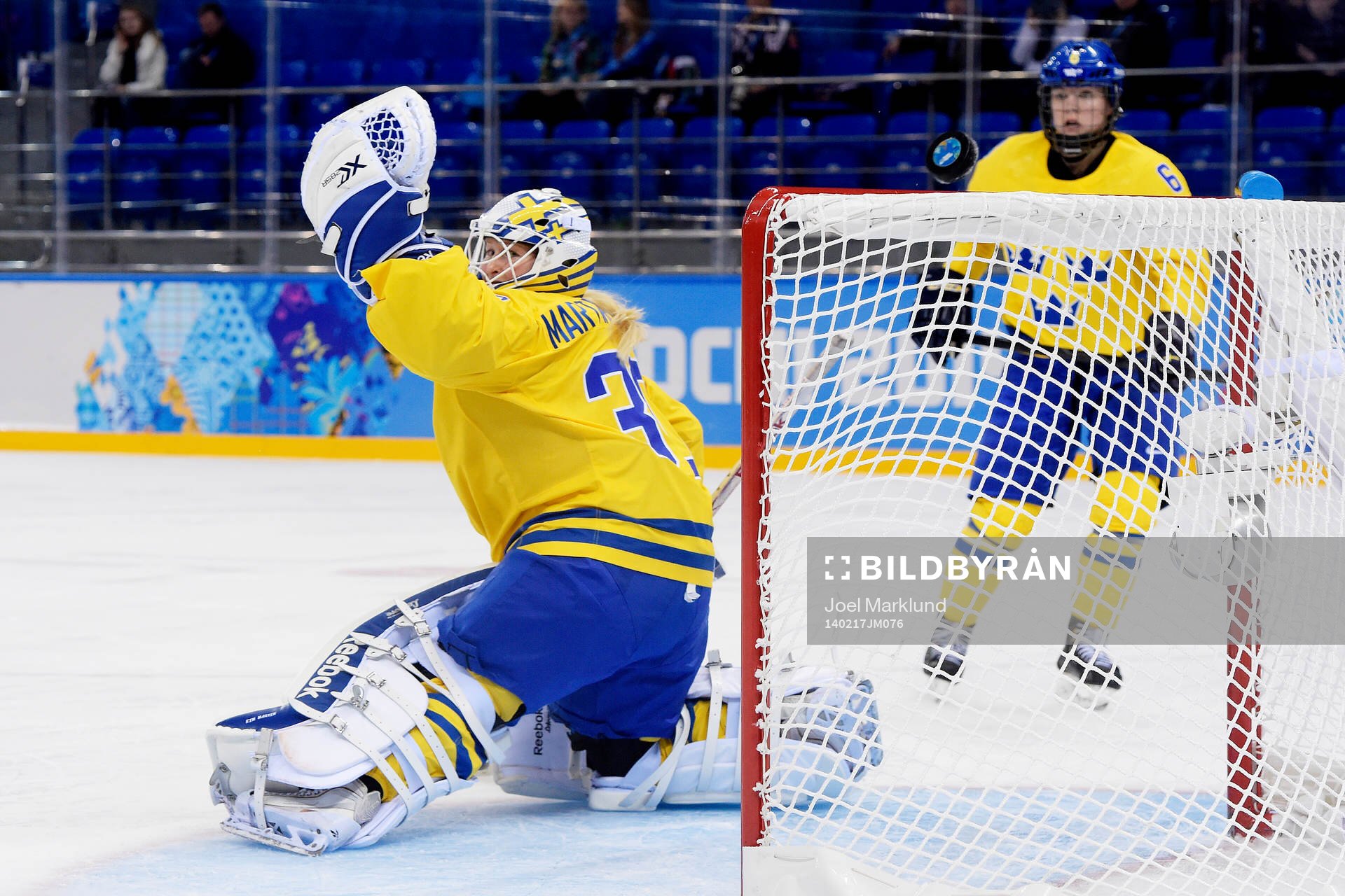 En puck flyger över Sveriges målvakt Kim Martin Hasson